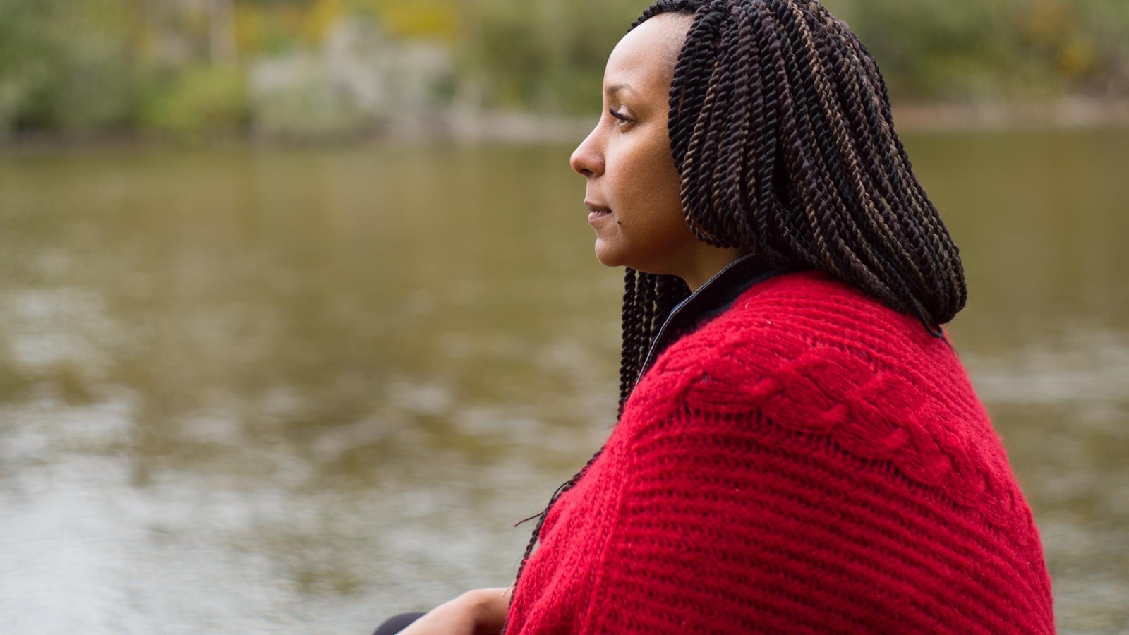 Sur le bord d'une rivière, une femme regarde au loin. Sur le bord d'une rivière, une femme regarde au loin.