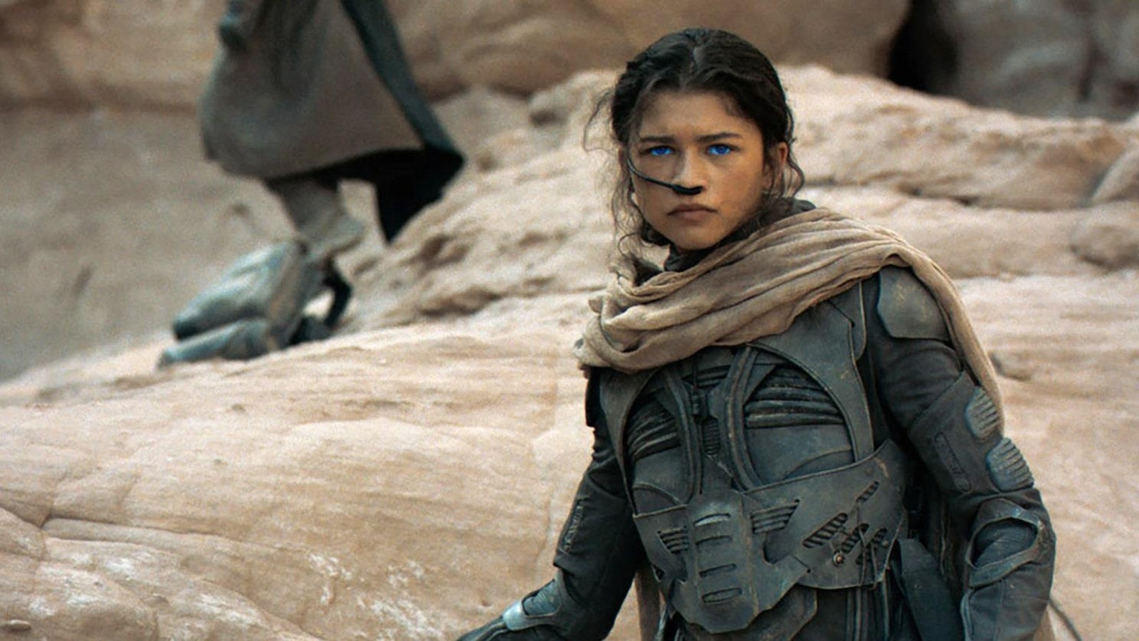 Une jeune femme (Zendaya) aux yeux bleus perçants en uniforme, avec un système de respiration dans le nez. Une jeune femme (Zendaya) aux yeux bleus perçants en uniforme, avec un système de respiration dans le nez.