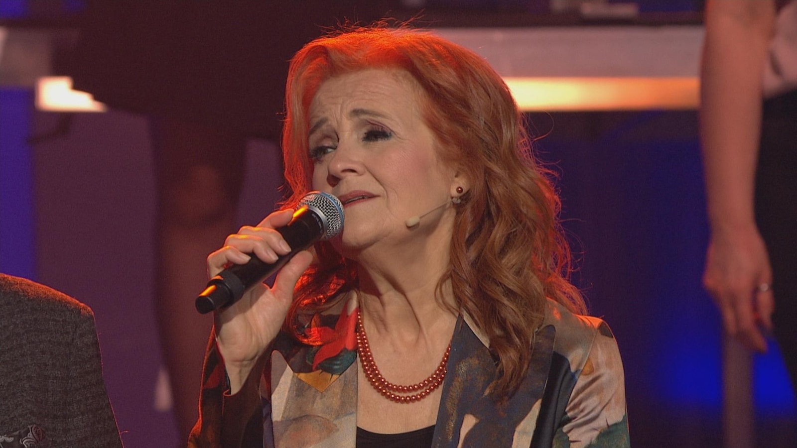 Marie-Denise Pelletier chante au micro. Marie-Denise Pelletier chante au micro.