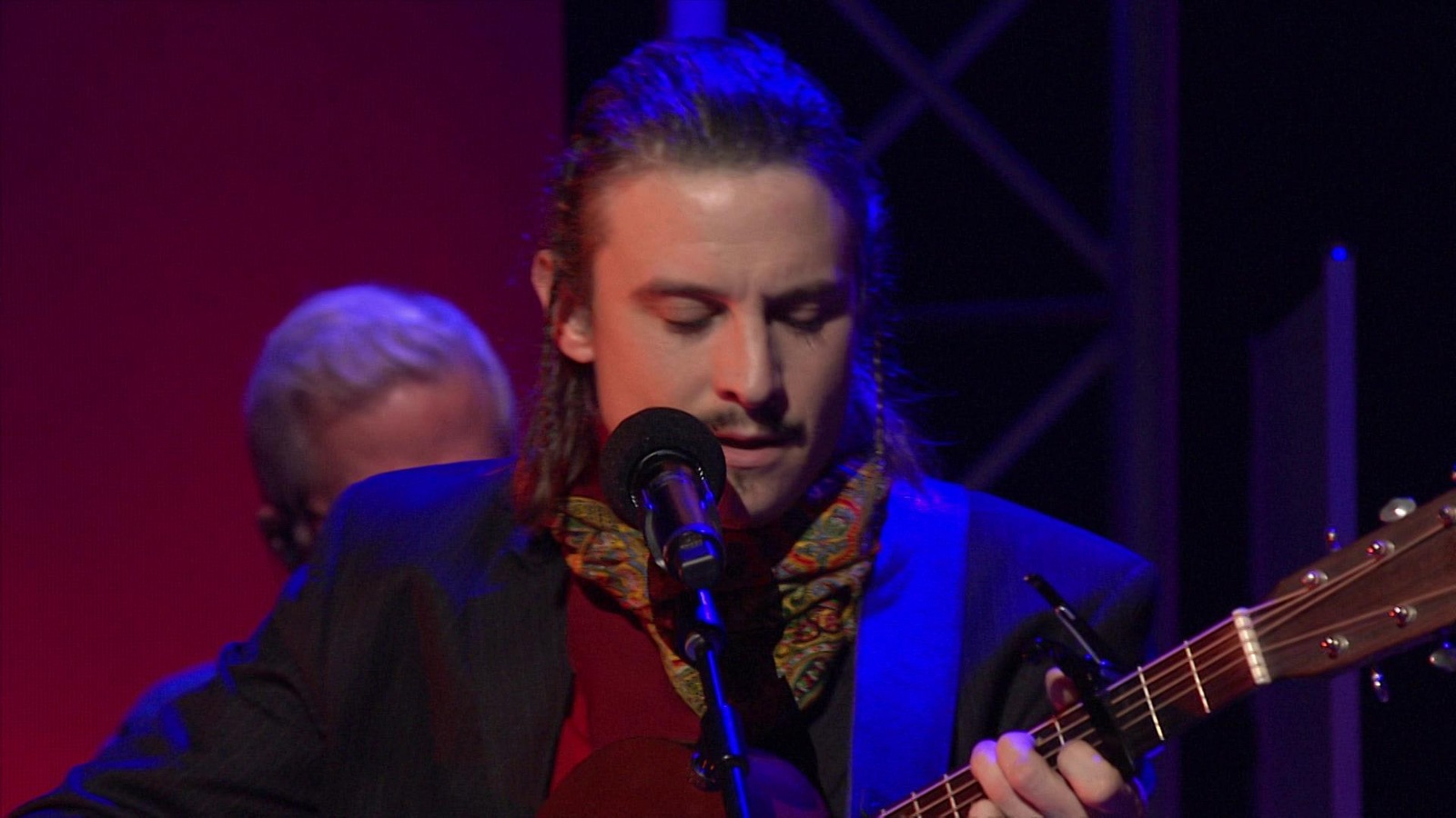 Elliot Maginot est au micro avec sa guitare sur le plateau d'En direct de l'univers. Elliot Maginot est au micro avec sa guitare sur le plateau d'En direct de l'univers.