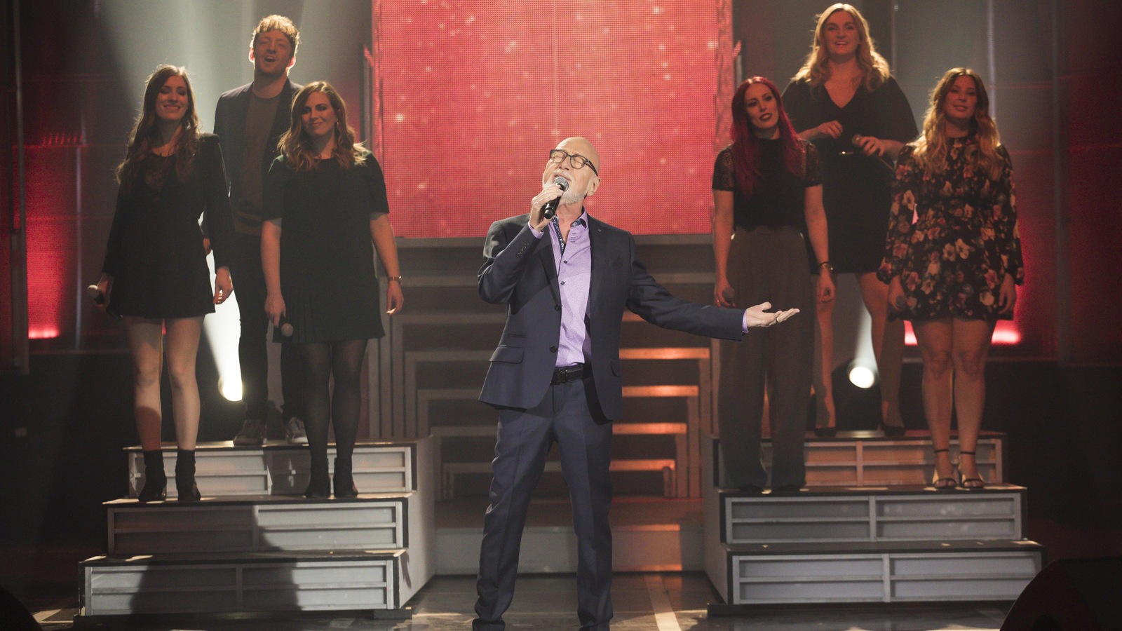 Sur la scène, Patrick Norman chante en tendant la main. Sur la scène, Patrick Norman chante en tendant la main.