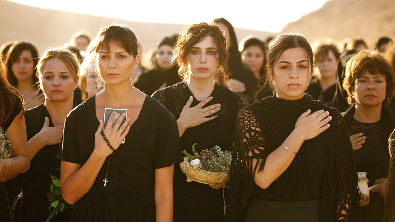 Un groupe de femmes habillées en noir, la main sur le coeur. Un groupe de femmes habillées en noir, la main sur le coeur.