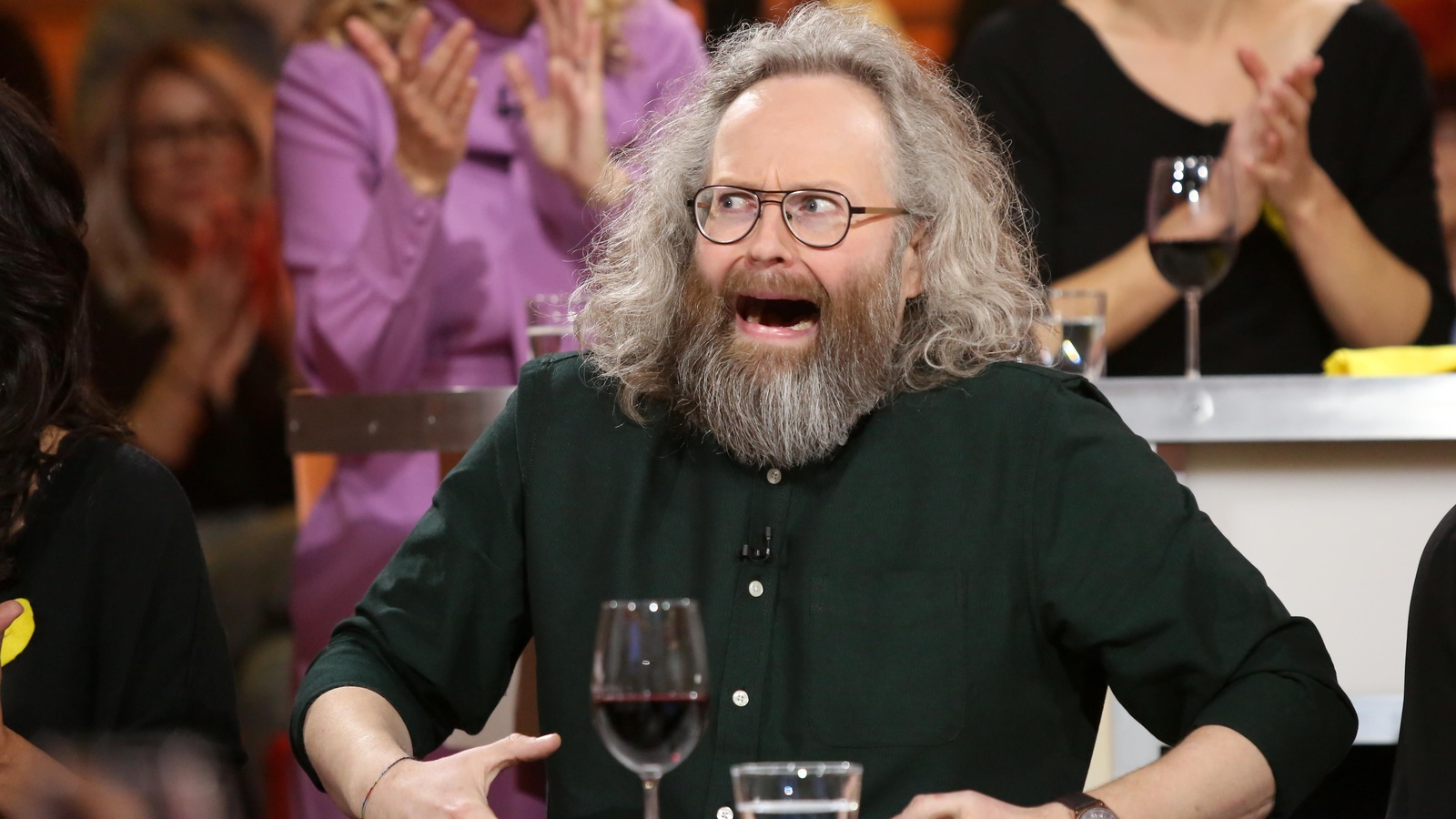 Il porte une chemise vert foncé. Il porte une chemise vert foncé.