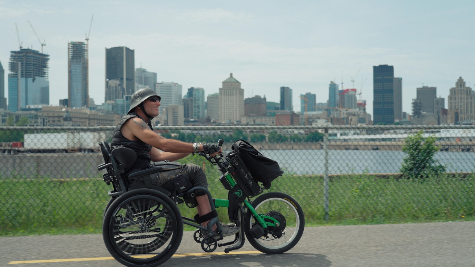 Un homme en situation de handicap roule sur un vélo adapté.