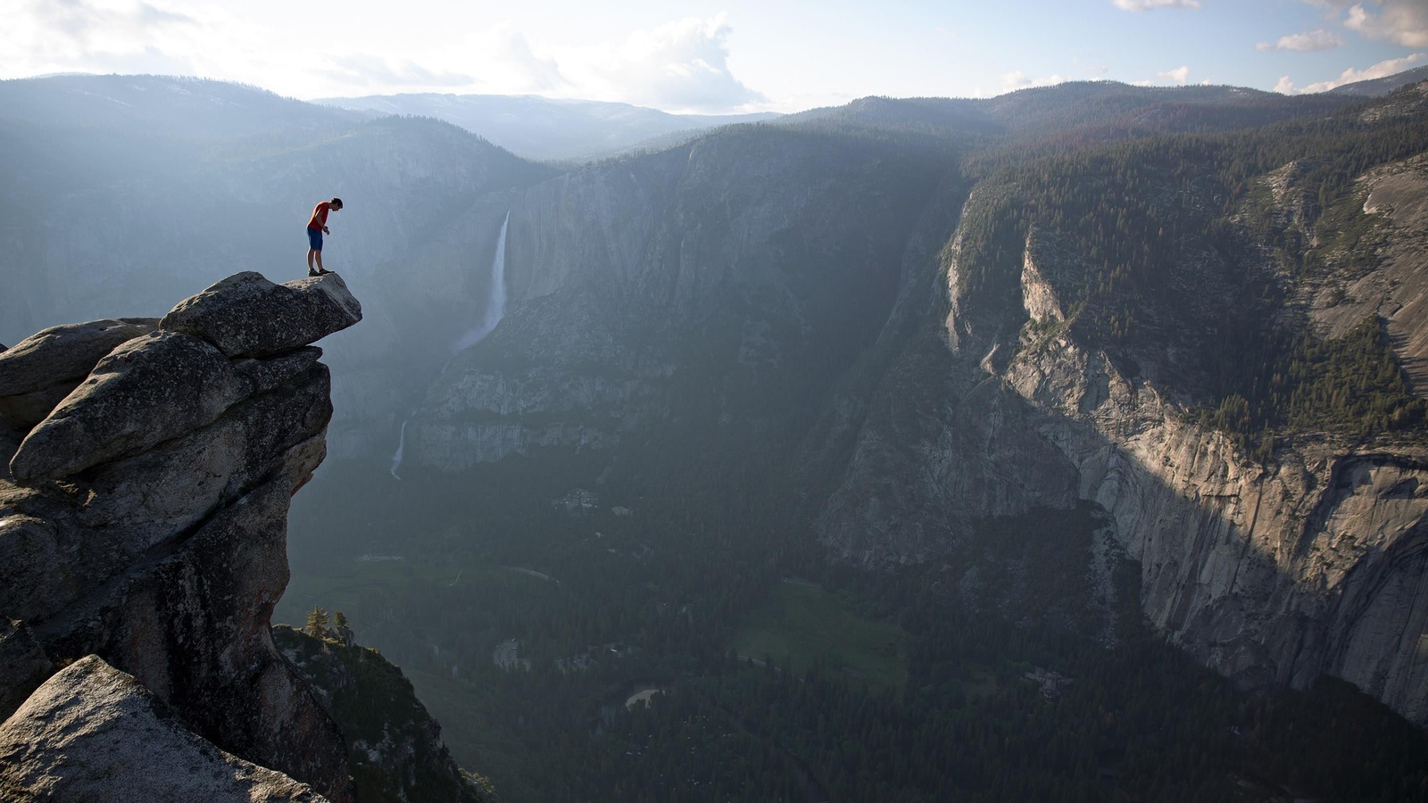 Un homme se tient seul au bord d'un précipice, sur une montagne. Un homme se tient seul au bord d'un précipice, sur une montagne.