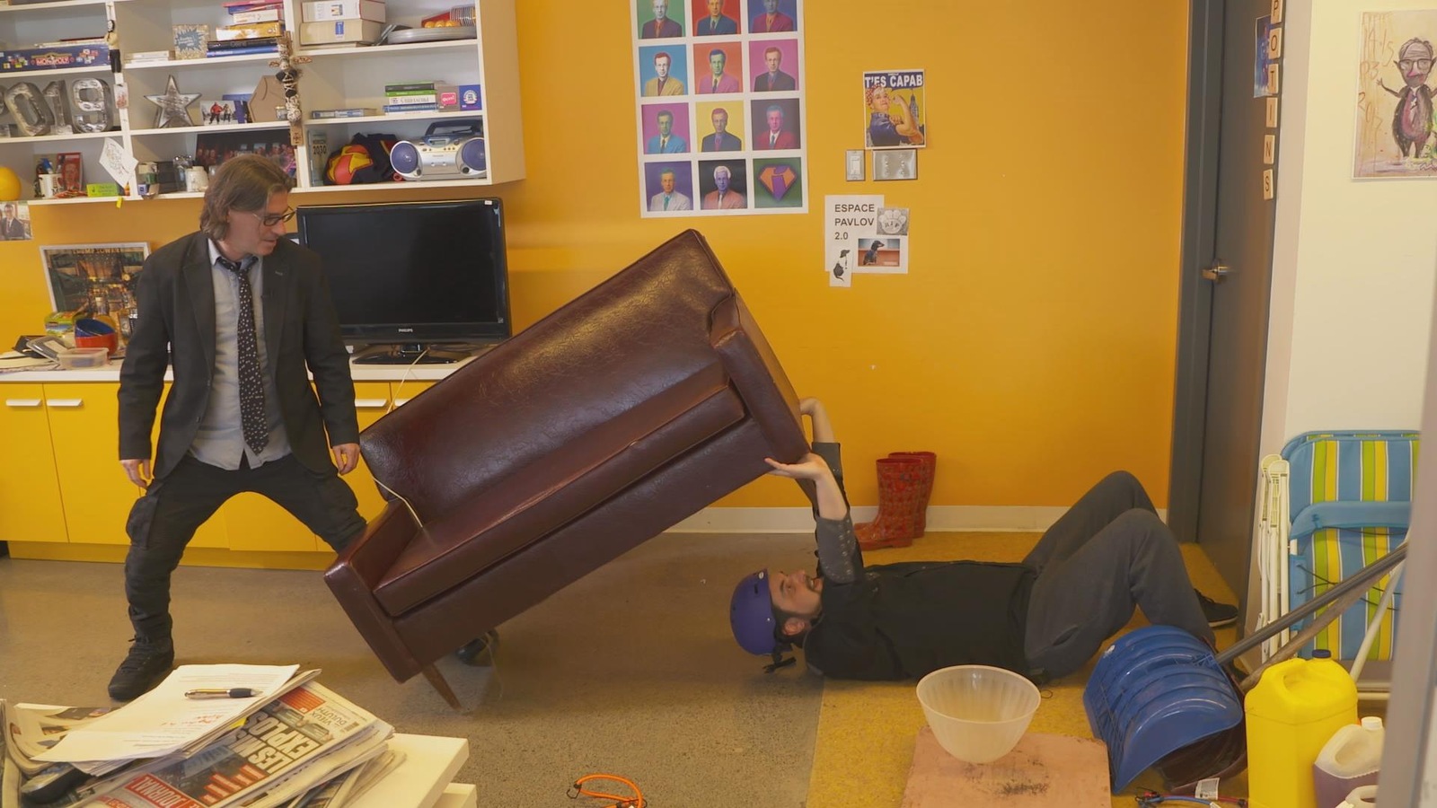 L'un des hommes soulève un sofa et l'autre le tient. L'un des hommes soulève un sofa et l'autre le tient.