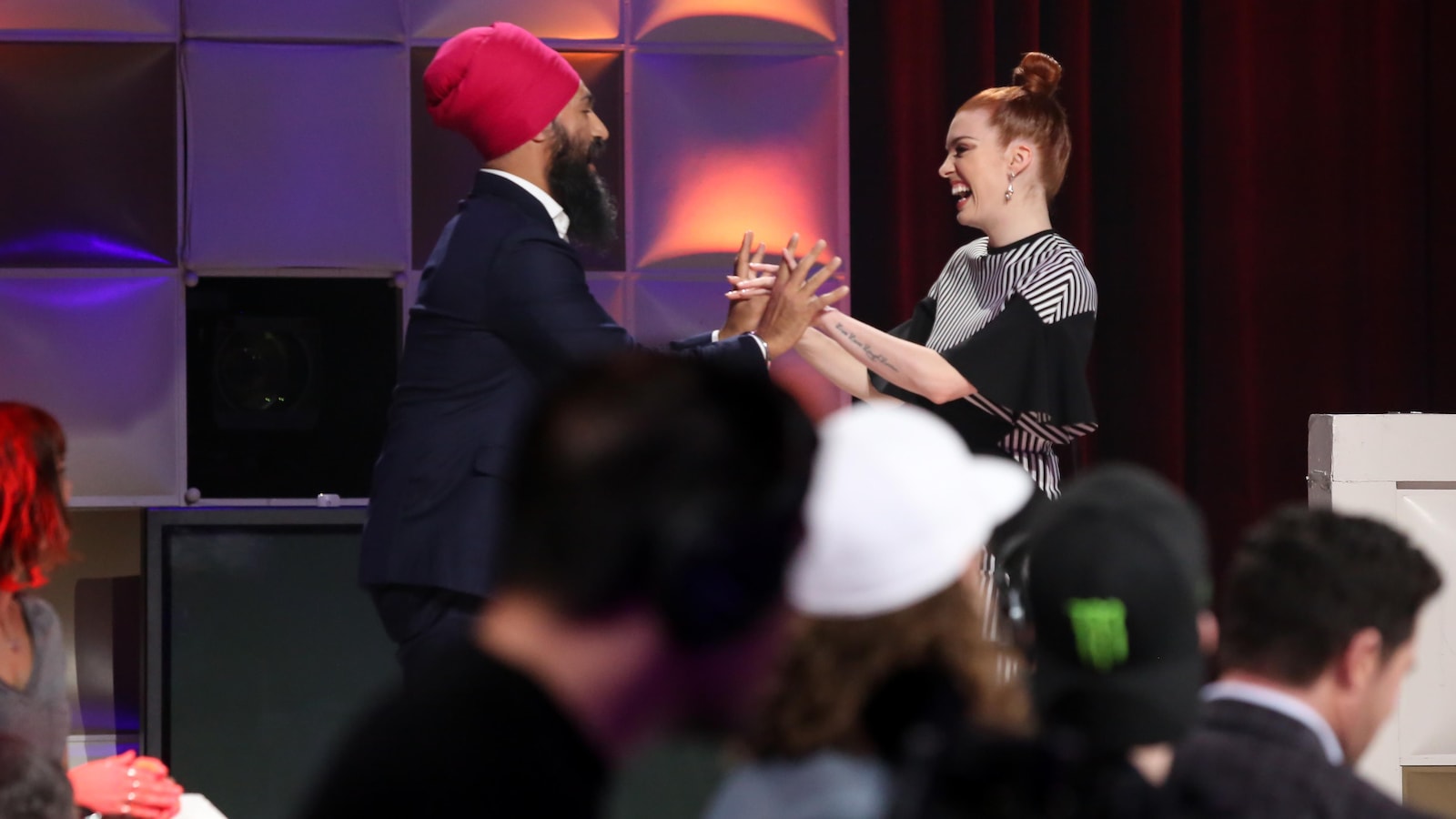Jagmeet Singh porte un habit bleu marin et un turban rose foncé. Kim Gingras porte une robe à rayures noires et blanches. Jagmeet Singh porte un habit bleu marin et un turban rose foncé. Kim Gingras porte une robe à rayures noires et blanches.