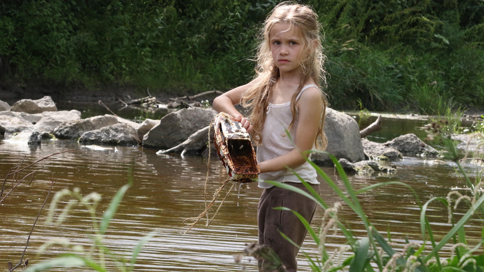 Une petite fille, les pieds dans l'eau et un jouet-bateau dans les mains. Une petite fille, les pieds dans l'eau et un jouet-bateau dans les mains.
