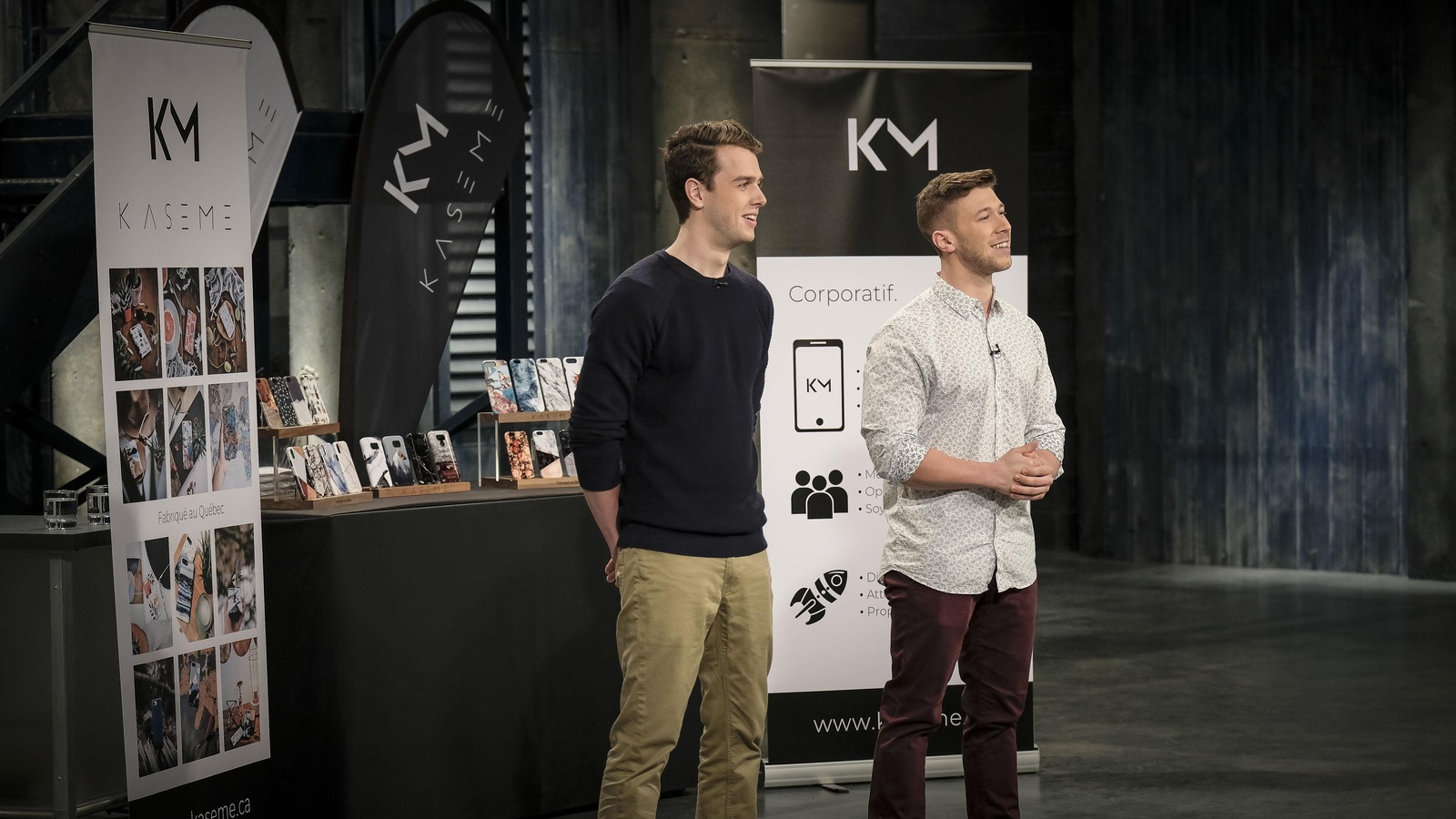 Deux jeunes hommes sont devant un présentoir d'étuis de téléphones cellulaires. Deux jeunes hommes sont devant un présentoir d'étuis de téléphones cellulaires.