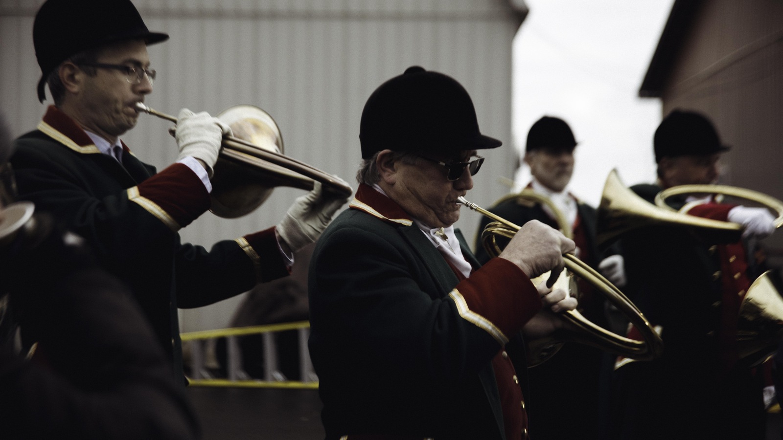 Plusieurs hommes en tenue traditionnelle jouent du cor de chasse. Plusieurs hommes en tenue traditionnelle jouent du cor de chasse.