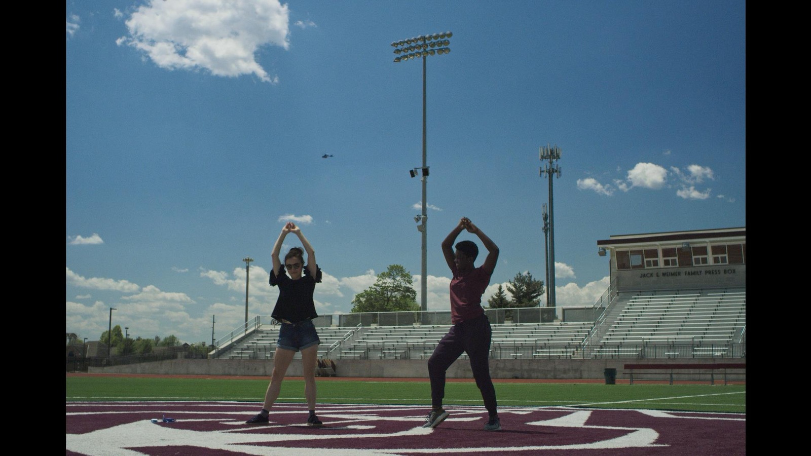 Deux jeunes filles font de l'exercice au milieu d'un stade en plein air. Deux jeunes filles font de l'exercice au milieu d'un stade en plein air.