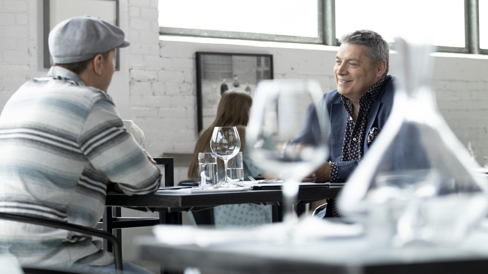 Ils discutent, face à face, dans un restaurant. 