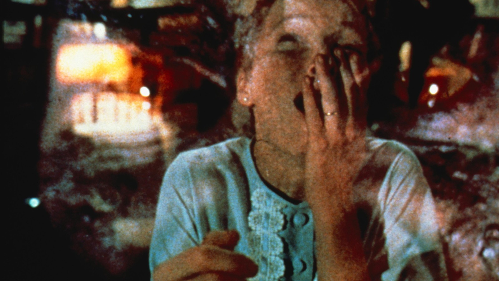 Une jeune femme la main sur la bouche, une image démoniaque en surimpression
Une jeune femme la main sur la bouche, une image démoniaque en surimpression