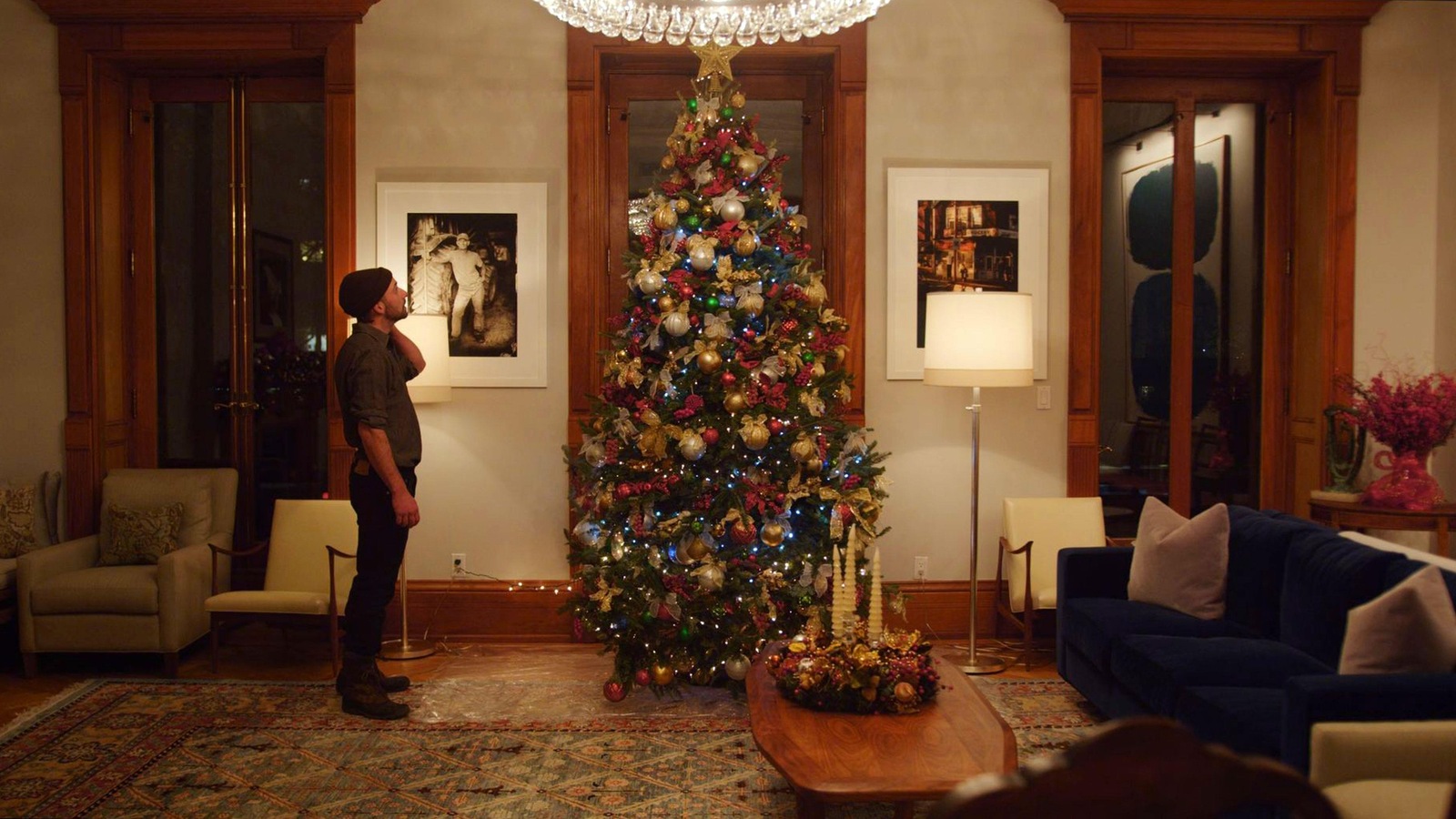 Un homme, dans un salon, face à un arbre de Noël richement décoré. Un homme, dans un salon, face à un arbre de Noël richement décoré.
