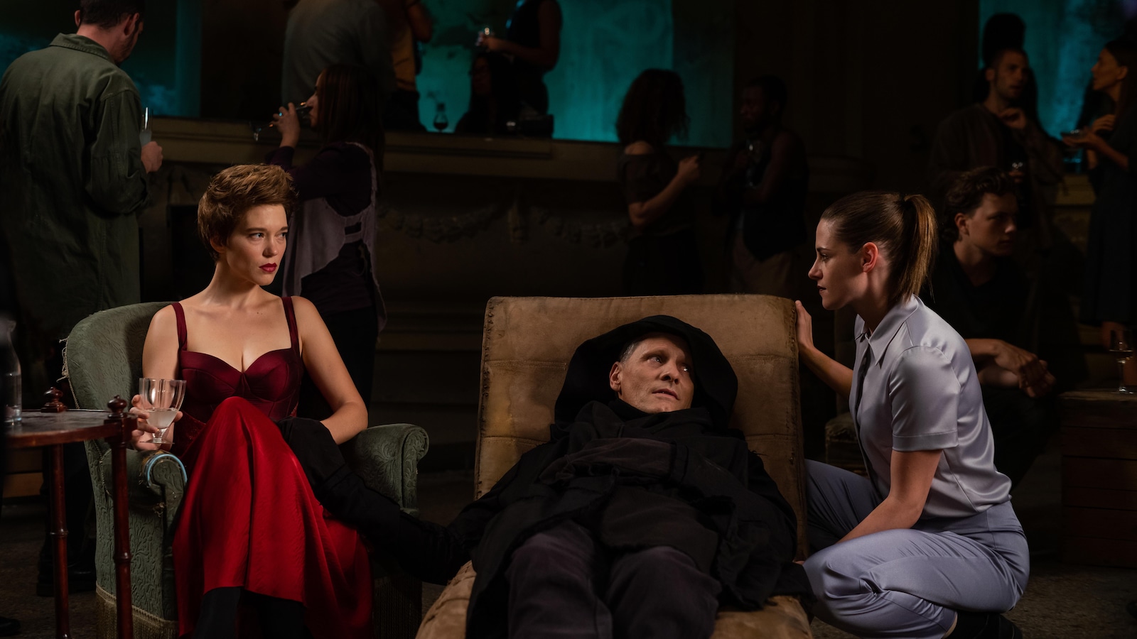 Deux femmes (Léa Seydoux et Kristin Stewart) assises à côté d'un homme allongé (Viggo Mortensen).