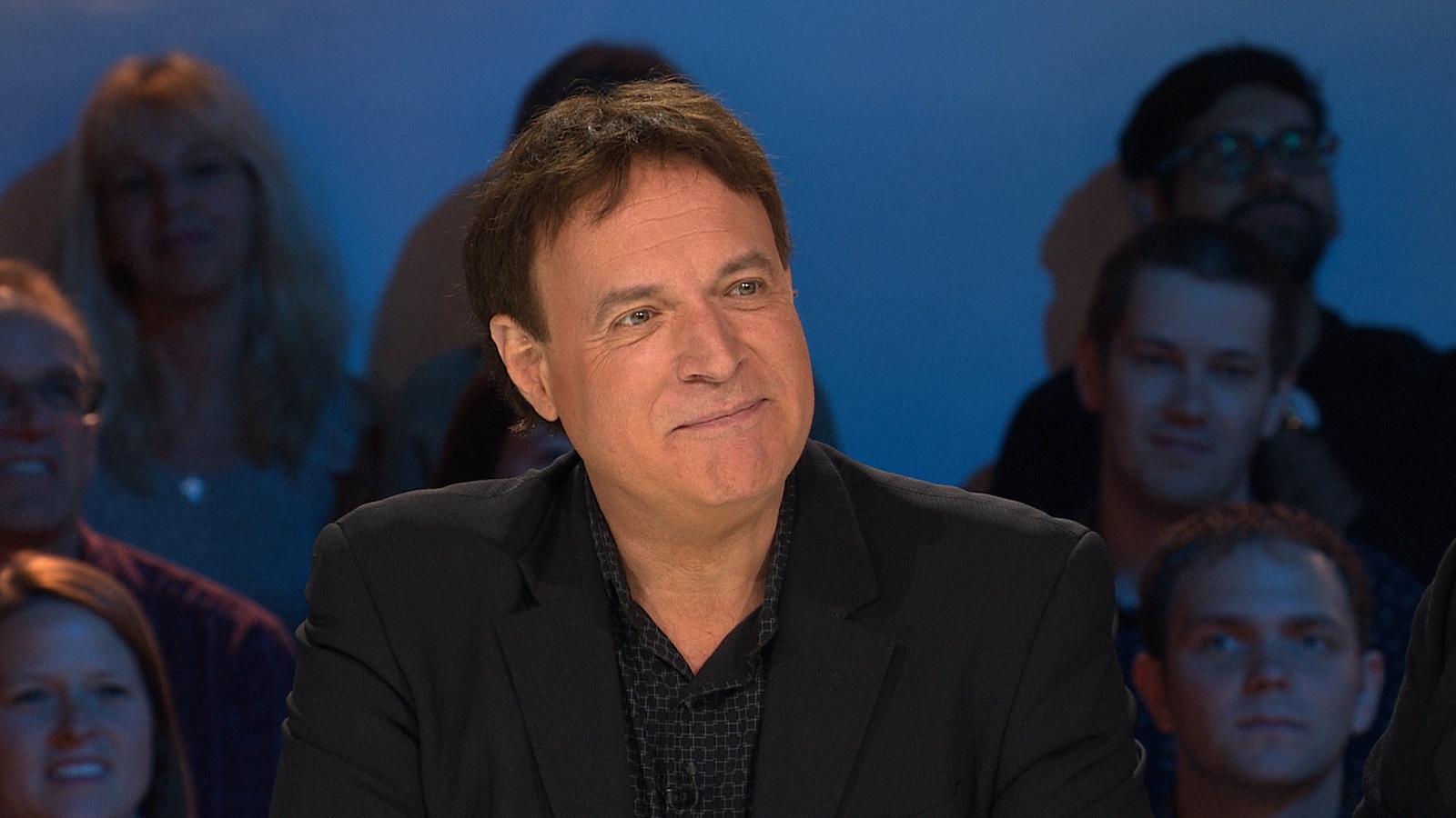 Bruno Landry sourit, assis sur le plateau des Enfants de la télé. Bruno Landry sourit, assis sur le plateau des Enfants de la télé.