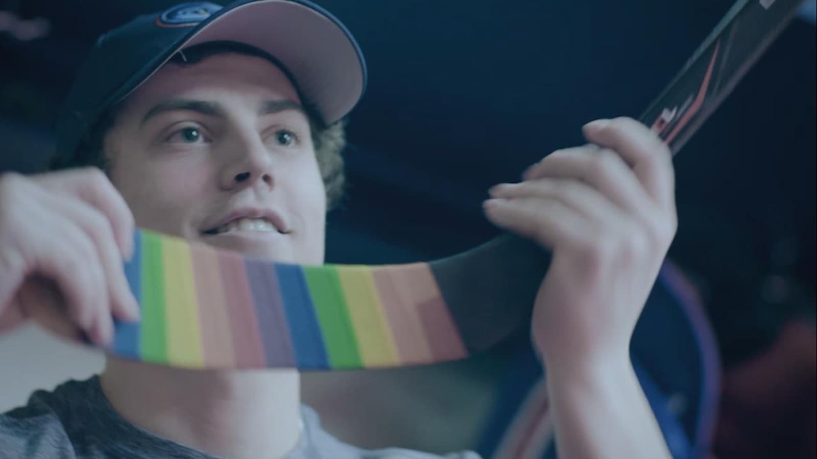Un joueur de hockey a enroulé son bâton d'un ruban aux couleurs de l'arc-en-ciel.