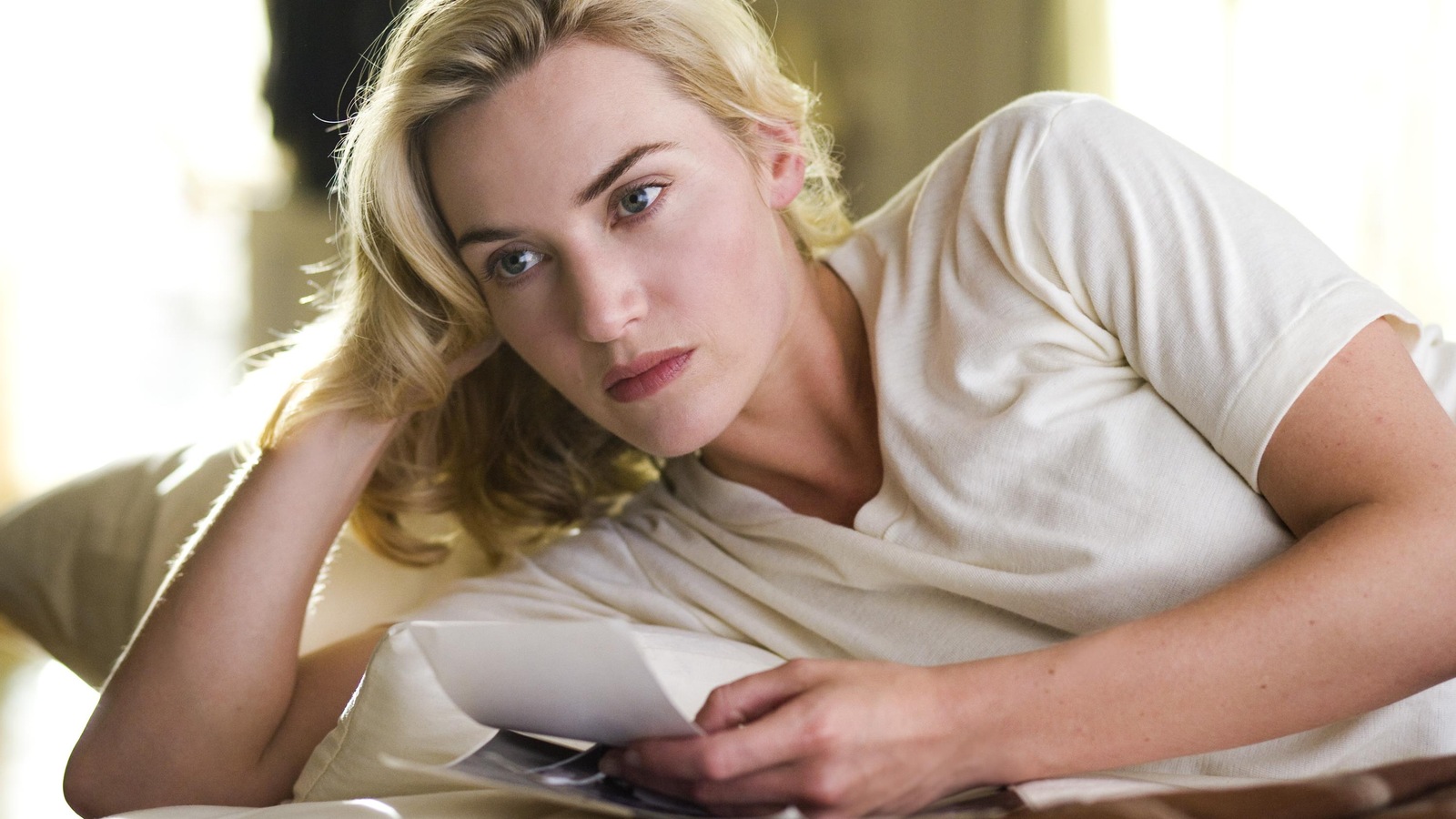 Une femme blonde, en t-shirt blanc, allongée sur le côté. Une femme blonde, en t-shirt blanc, allongée sur le côté.