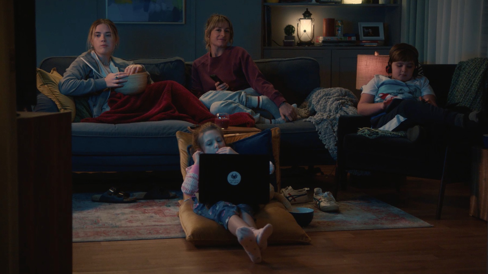 Isabelle (Christine Beaulieu) regarde la télé avec ses trois enfants.