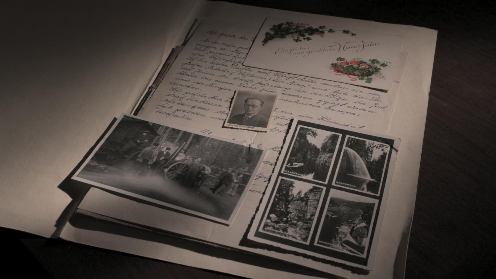 Dans un album de type scrapbook, on retrouve une lettre, une enveloppe et de vieilles photos de l'époque de la Deuxième Guerre. Dans un album de type scrapbook, on retrouve une lettre, une enveloppe et de vieilles photos de l'époque de la Deuxième Guerre.