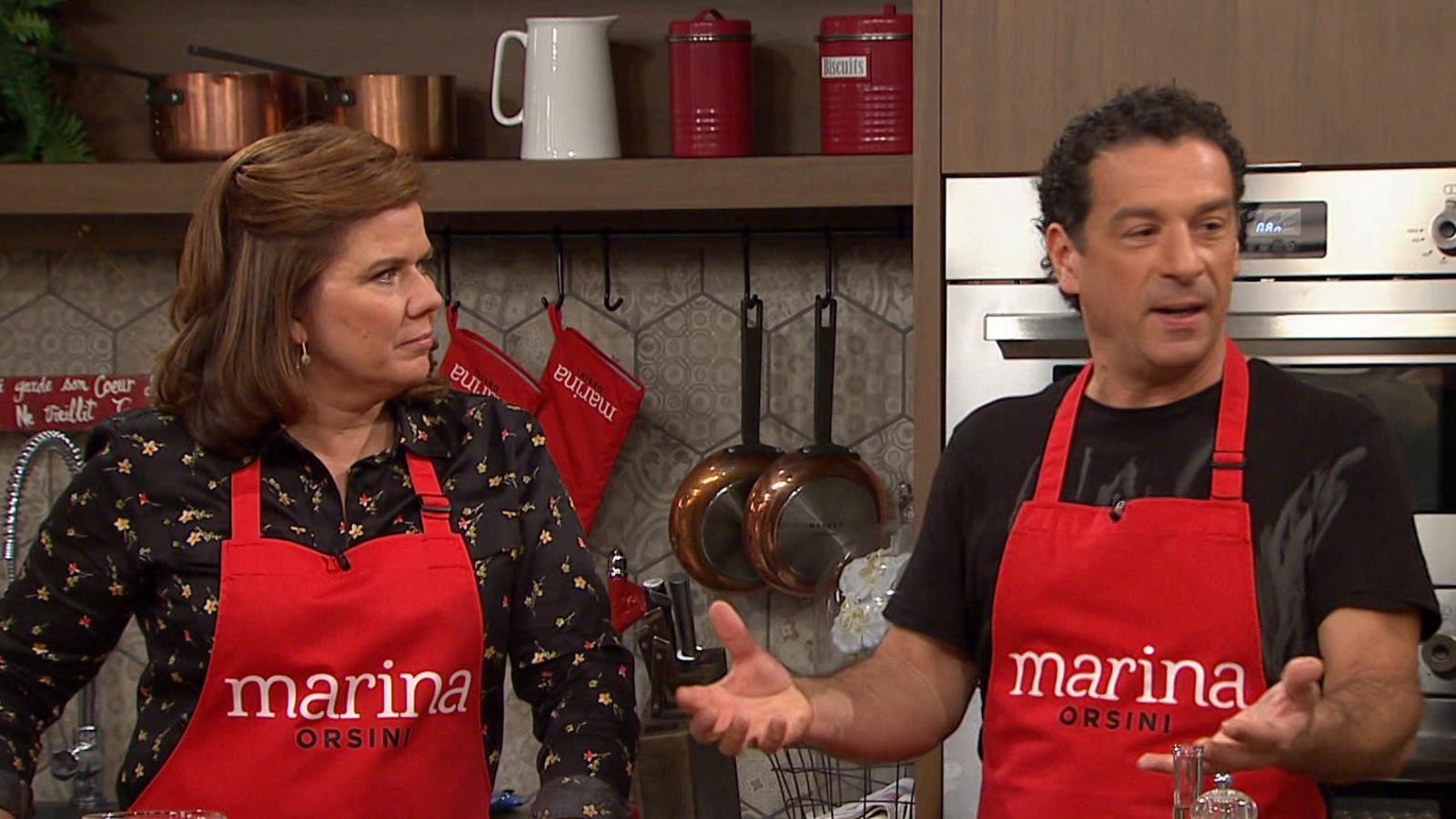 Les deux cuisinent et portent un tablier où il est écrit « Marina ». Les deux cuisinent et portent un tablier où il est écrit « Marina ».