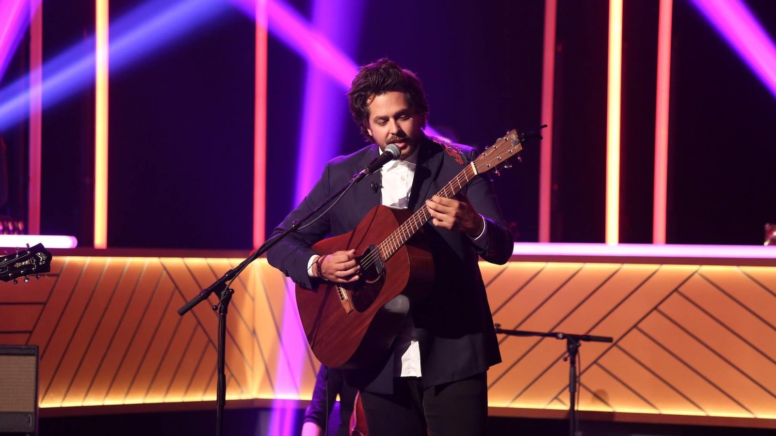 Il chante en s'accompagnant à la guitare Il chante en s'accompagnant à la guitare