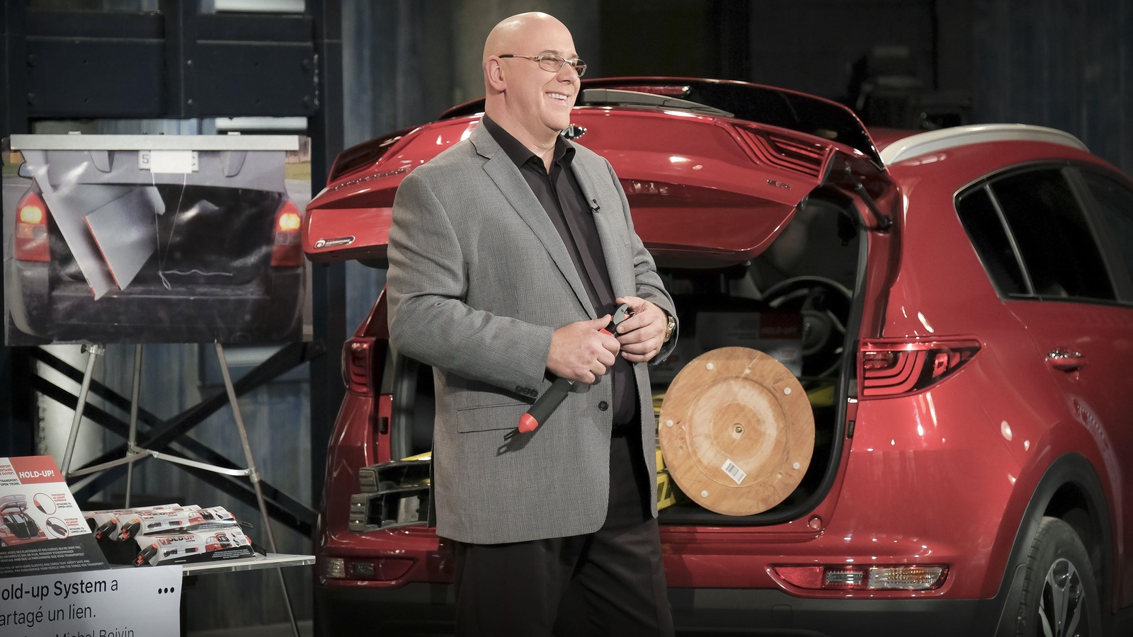 Michel est à côté d'une voiture rouge dont le coffre est ouvert. Michel est à côté d'une voiture rouge dont le coffre est ouvert.
