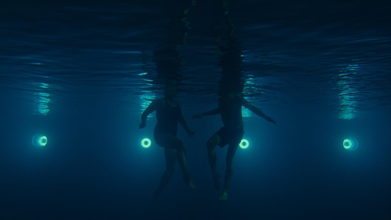 Le bas de deux corps vus sous l'eau. Le bas de deux corps vus sous l'eau.