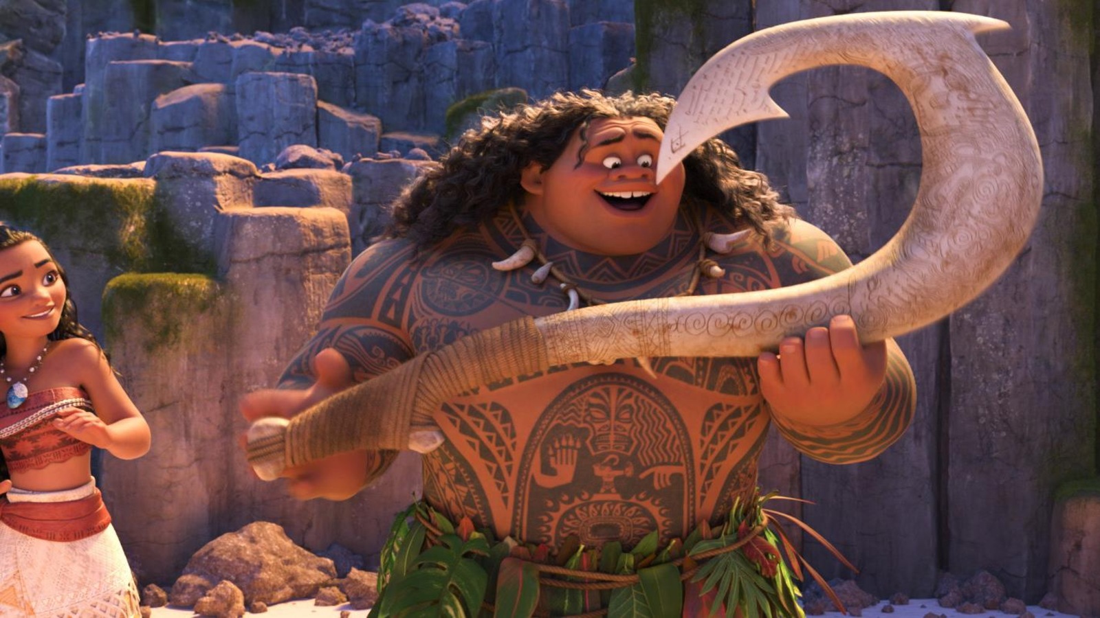 Une image du dessin animé Moana montrant l'héroïne sur une plage, à côté d'un demi-dieu couvert de tatouages et portant un instrument mythologique. Une image du dessin animé Moana montrant l'héroïne sur une plage, à côté d'un demi-dieu couvert de tatouages et portant un instrument mythologique.