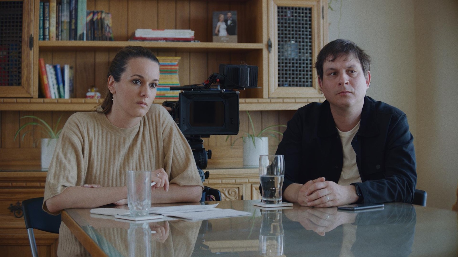 Les deux personnes sont assises à une table et une caméra est entre elles. Les deux personnes sont assises à une table et une caméra est entre elles.