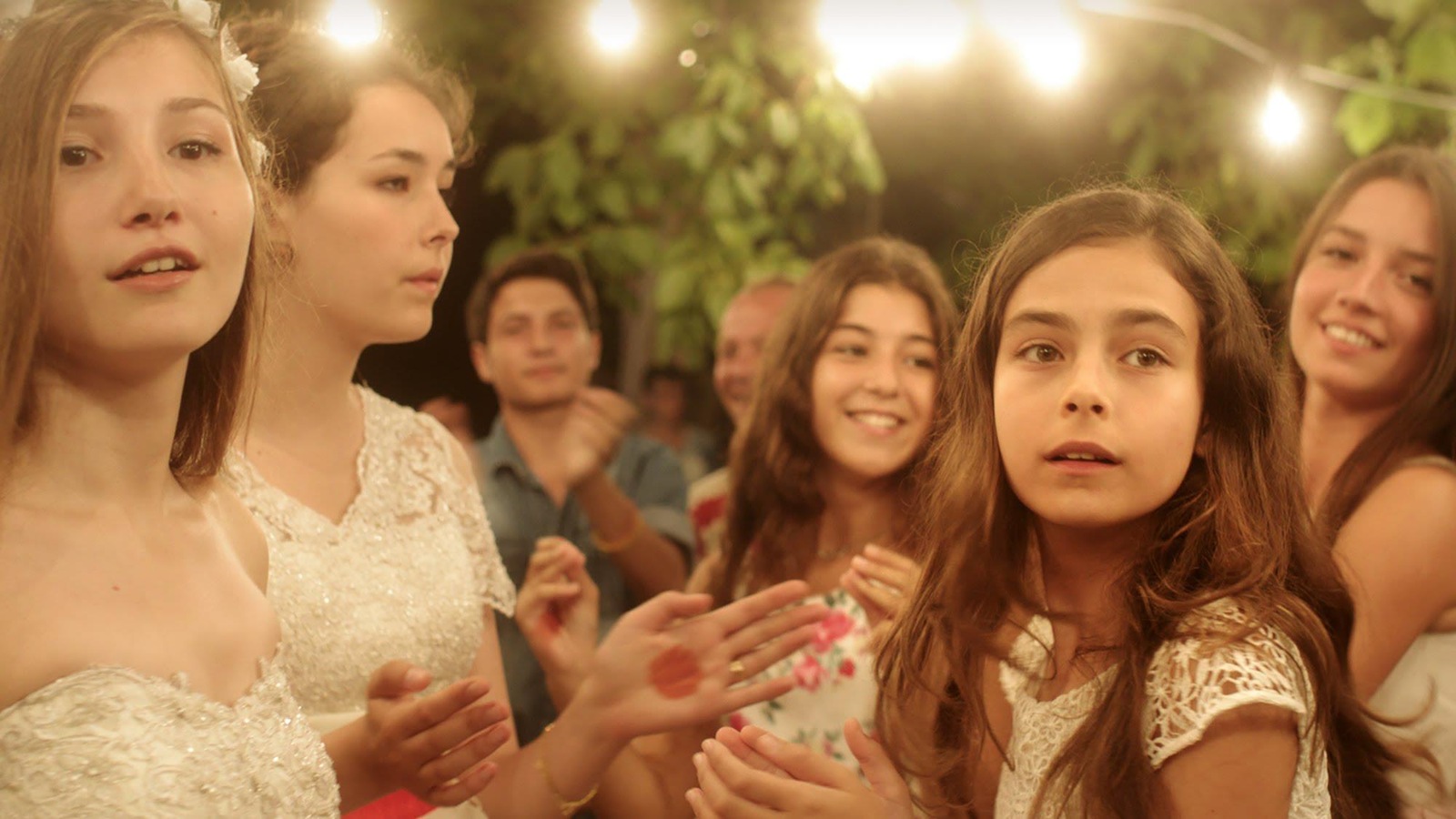 Cinq jeunes filles souriant, au milieu d'une fête à l'extérieur. Cinq jeunes filles souriant, au milieu d'une fête à l'extérieur.