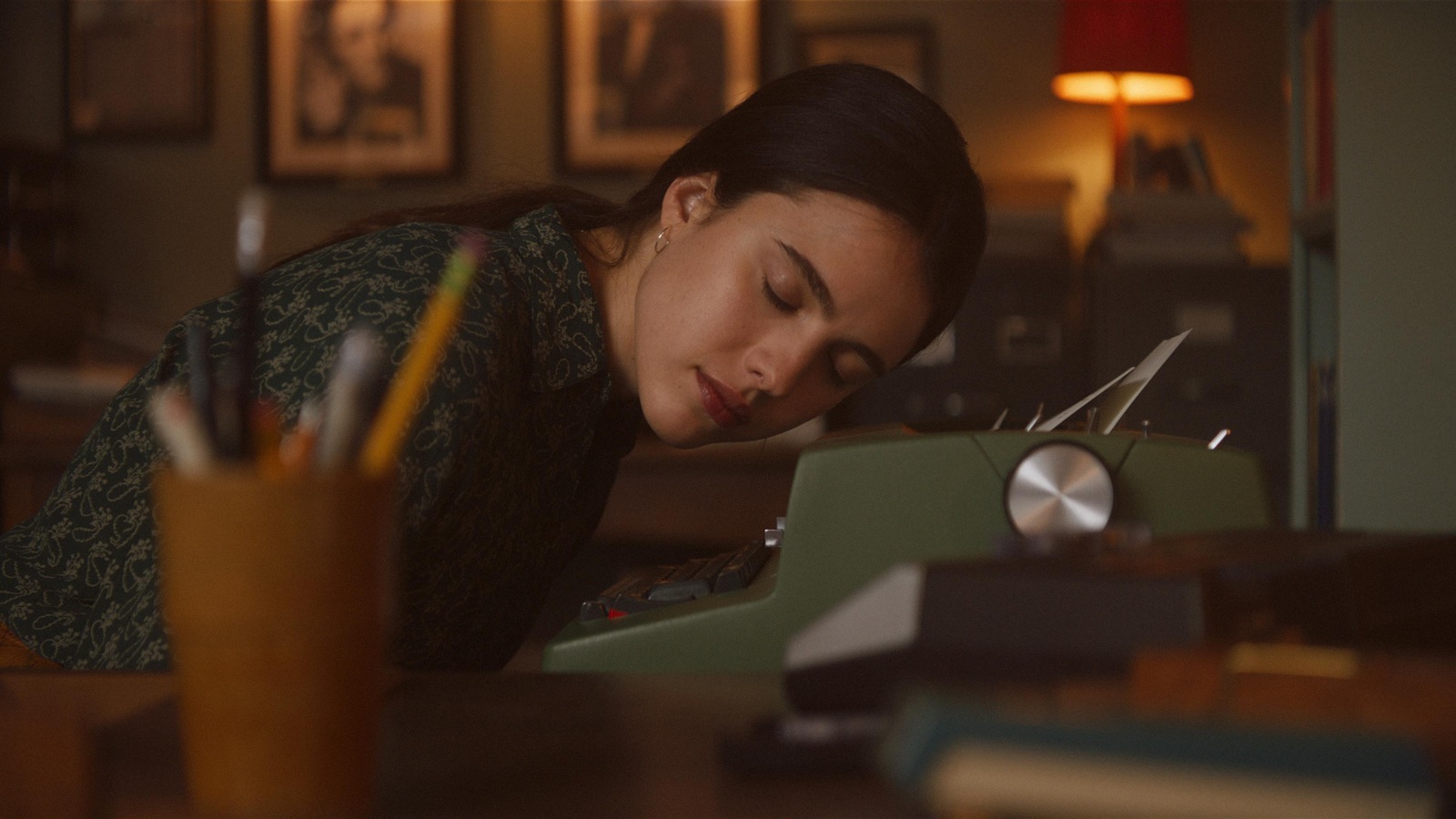 Une jeune femme (Margaret Qualley) de profil, penchée sur sa machine à écrire. Une jeune femme (Margaret Qualley) de profil, penchée sur sa machine à écrire.