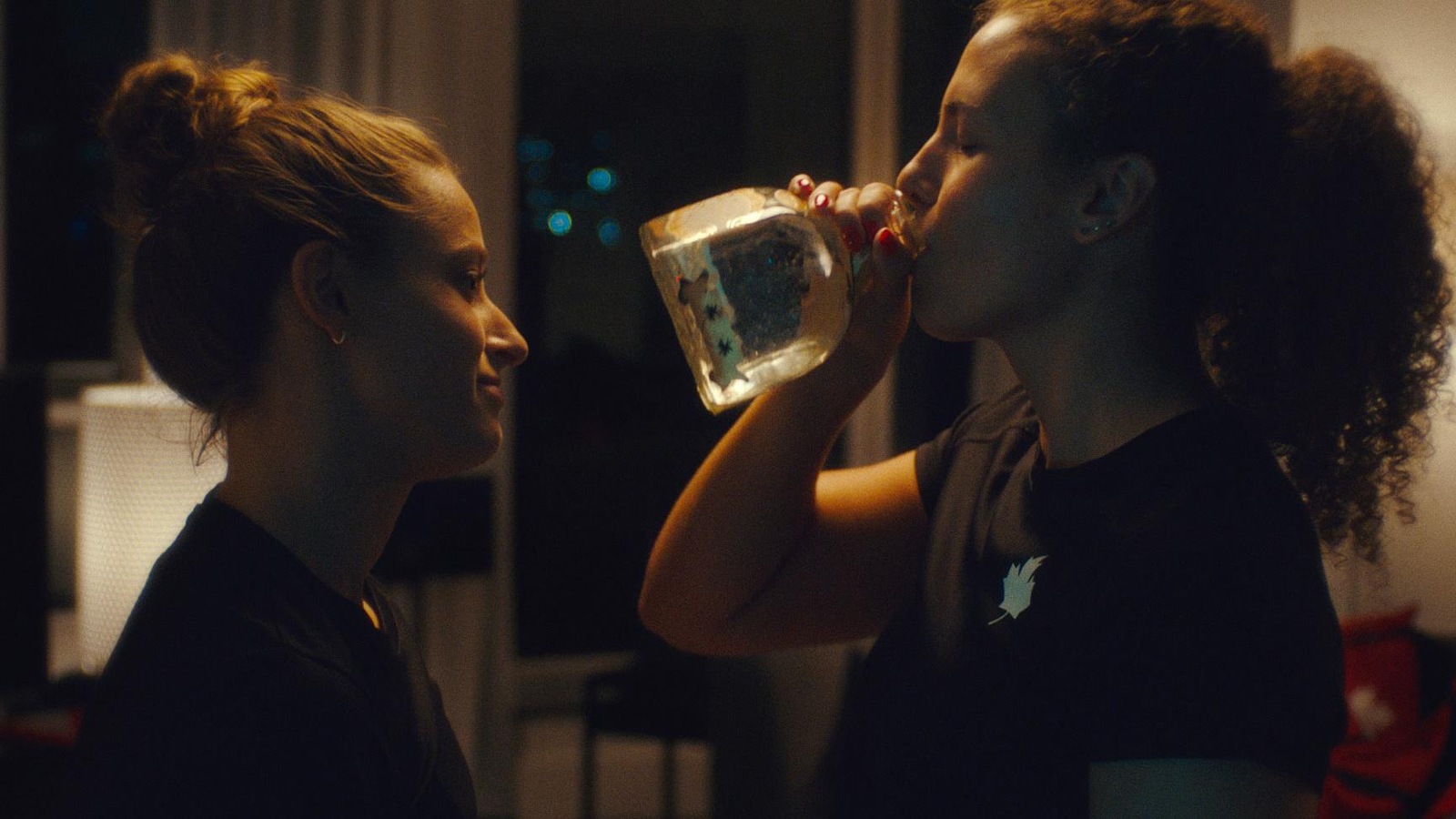 Deux jeunes femmes (Katerine Savard et Ariane Mainville) face à face boivent de l'alcool à la bouteille. Deux jeunes femmes (Katerine Savard et Ariane Mainville) face à face boivent de l'alcool à la bouteille.