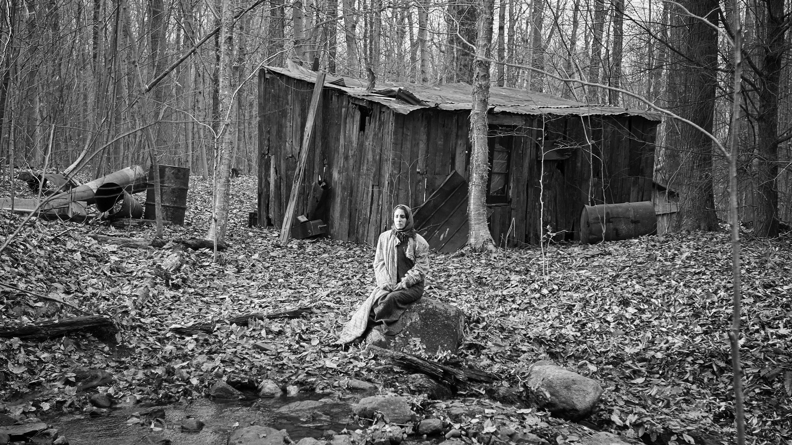 En noir et blanc, une femme (Nathalie Doummar) assise sur une souche dans la forêt. En noir et blanc, une femme (Nathalie Doummar) assise sur une souche dans la forêt.