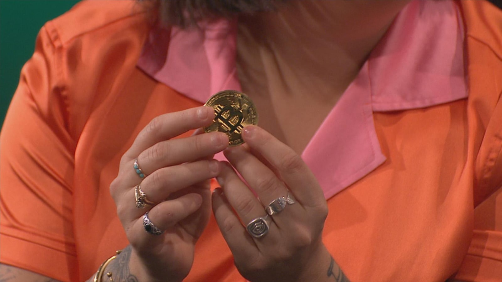 Mariana Mazza tient une pièce représentant un bitcoin dans les mains.