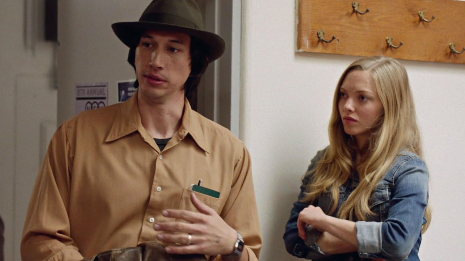 Un homme avec un chapeau (Adam Driver) et une femme (Amanda Seyfried), dans un couloir. Un homme avec un chapeau (Adam Driver) et une femme (Amanda Seyfried), dans un couloir.