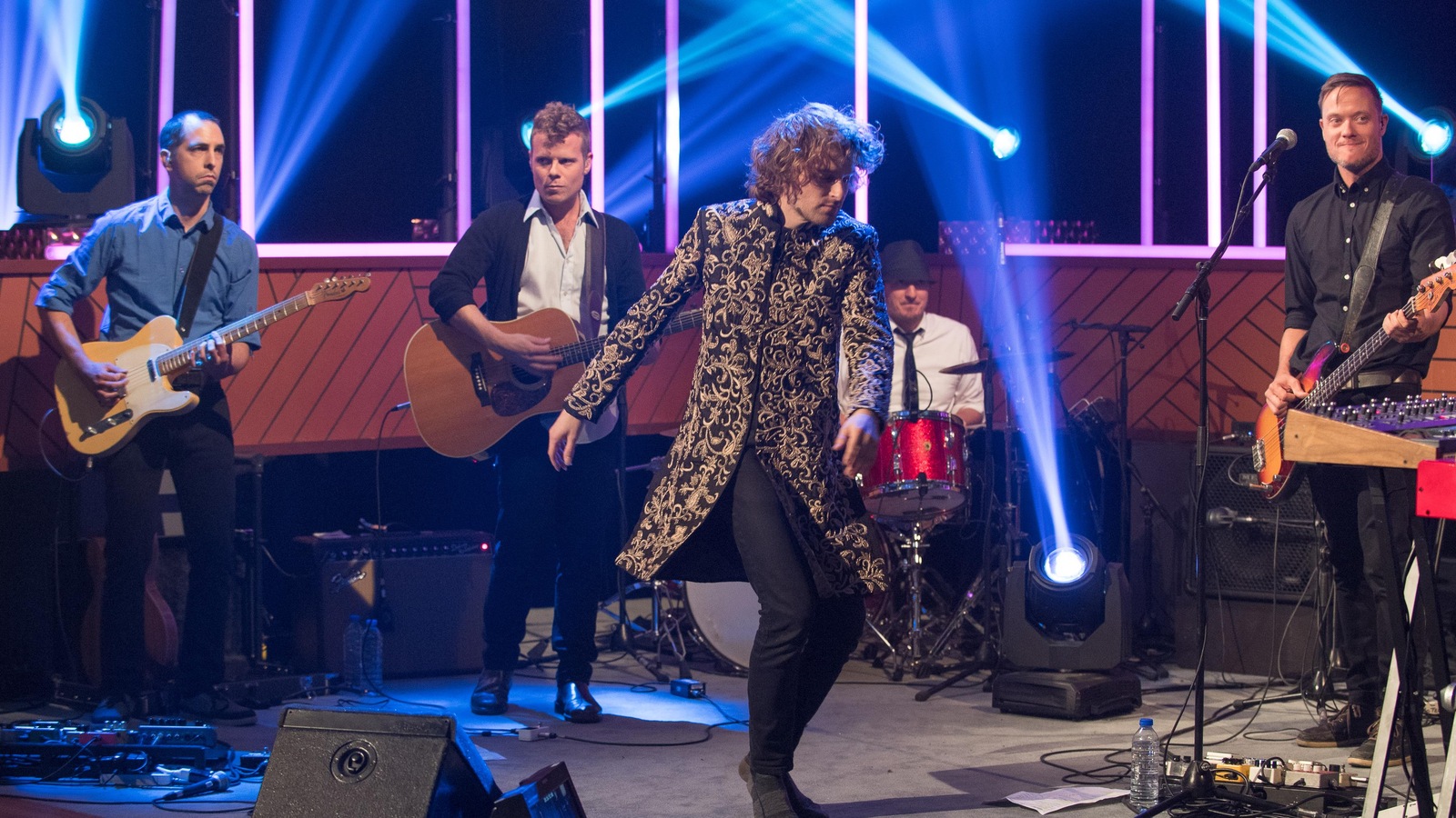 Il porte une redingote et danse au milieu de son groupe Il porte une redingote et danse au milieu de son groupe