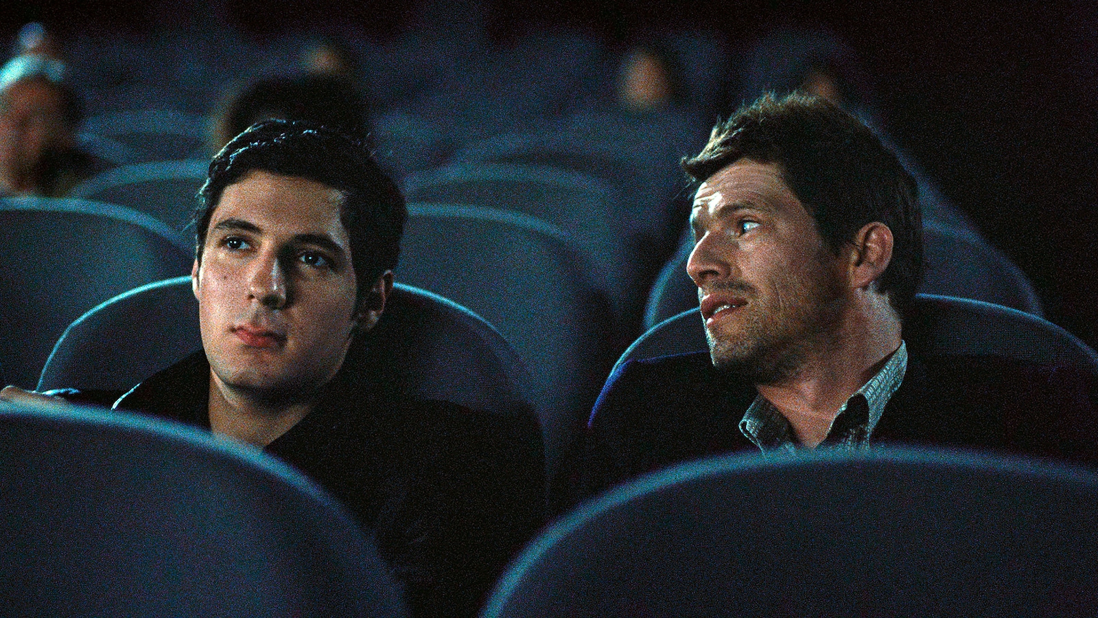 Deux hommes dans une salle de cinéma aux fauteuils bleus. Deux hommes dans une salle de cinéma aux fauteuils bleus.