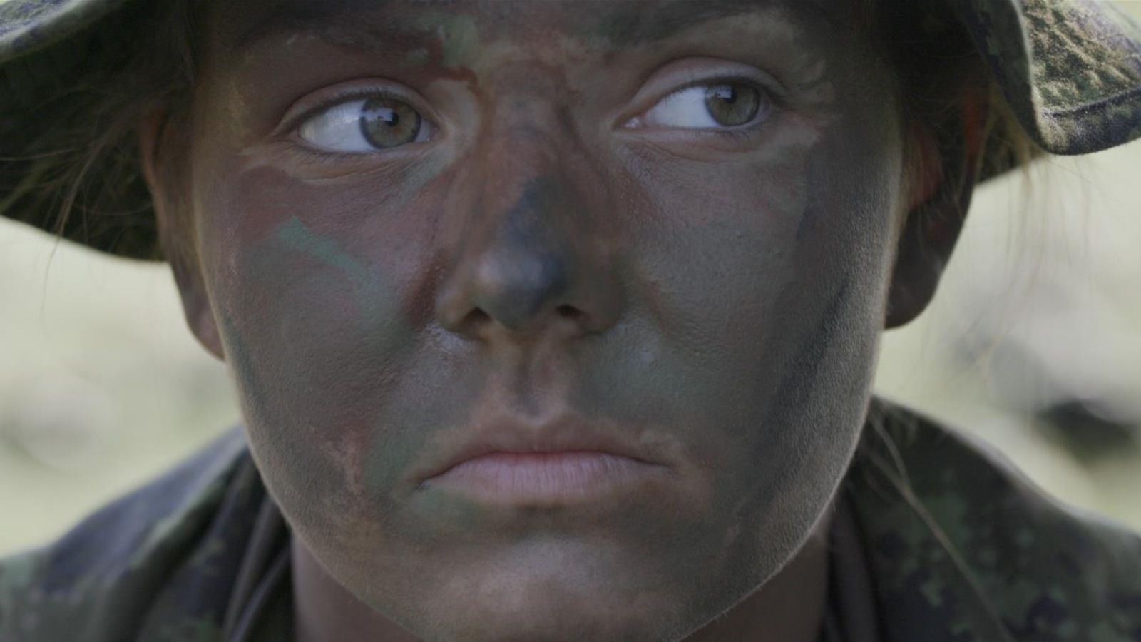 Une jeune femme avec du maquillage de camouflage sur le visage Une jeune femme avec du maquillage de camouflage sur le visage
