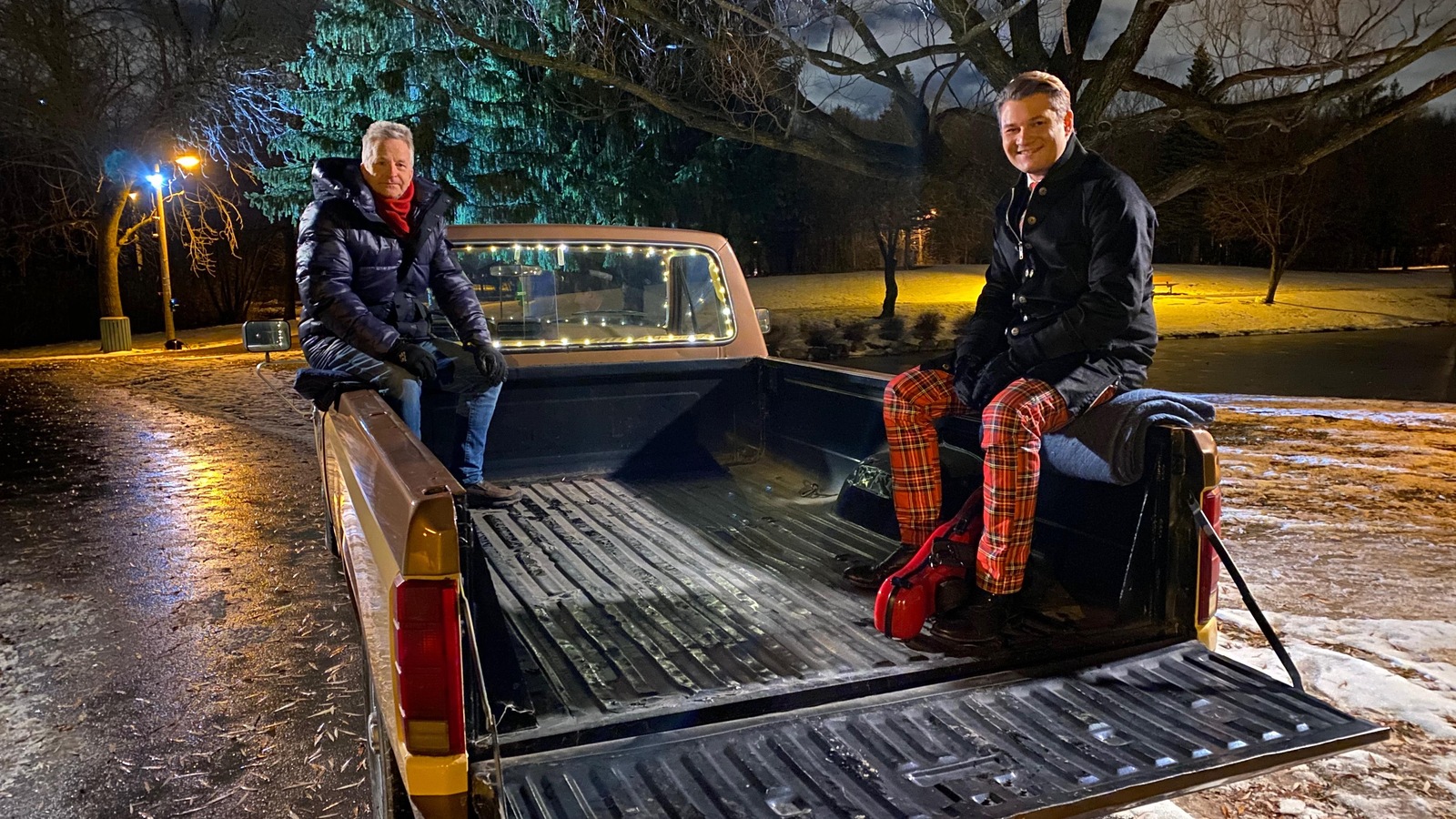 Les deux hommes sont assis à l'arrière d'un pick up. Les deux hommes sont assis à l'arrière d'un pick up.