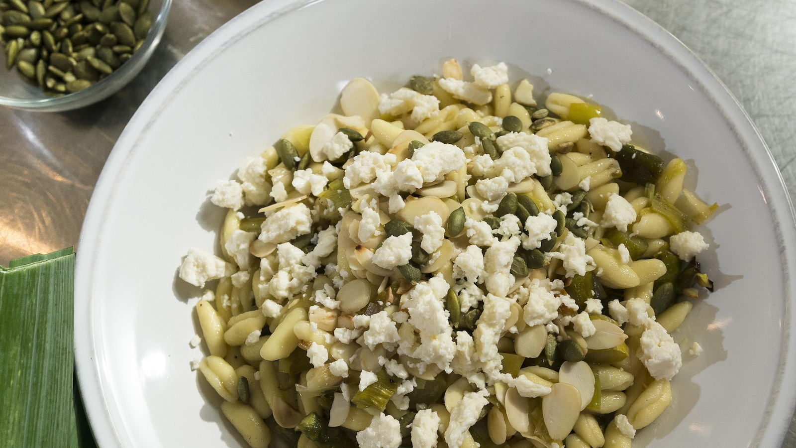 Un bol de pâtes avec des amandes grillées, des graines et du fromage émietté. Un bol de pâtes avec des amandes grillées, des graines et du fromage émietté.