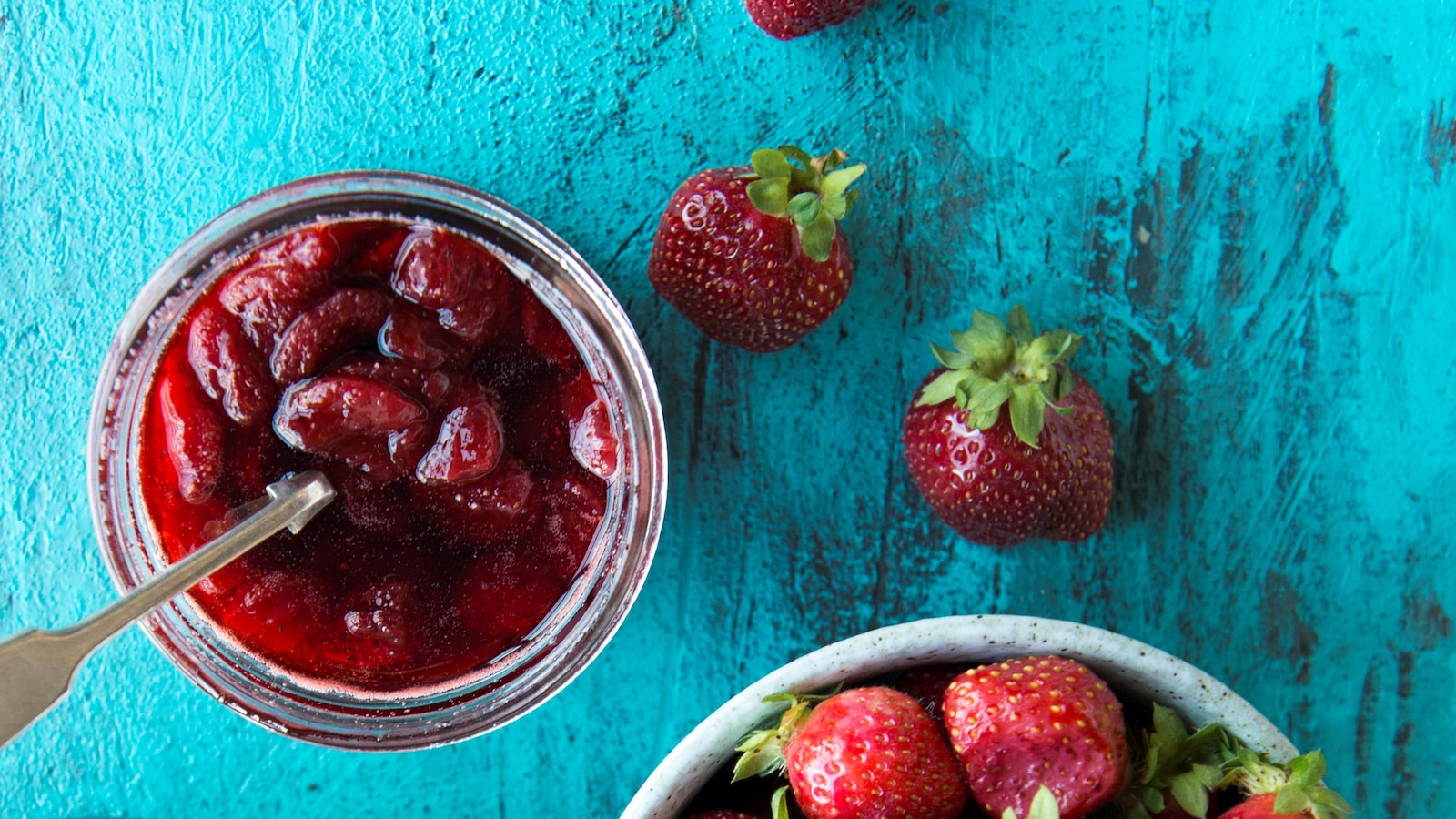Un pot de confiture à côté de fraises mûres. Un pot de confiture à côté de fraises mûres.