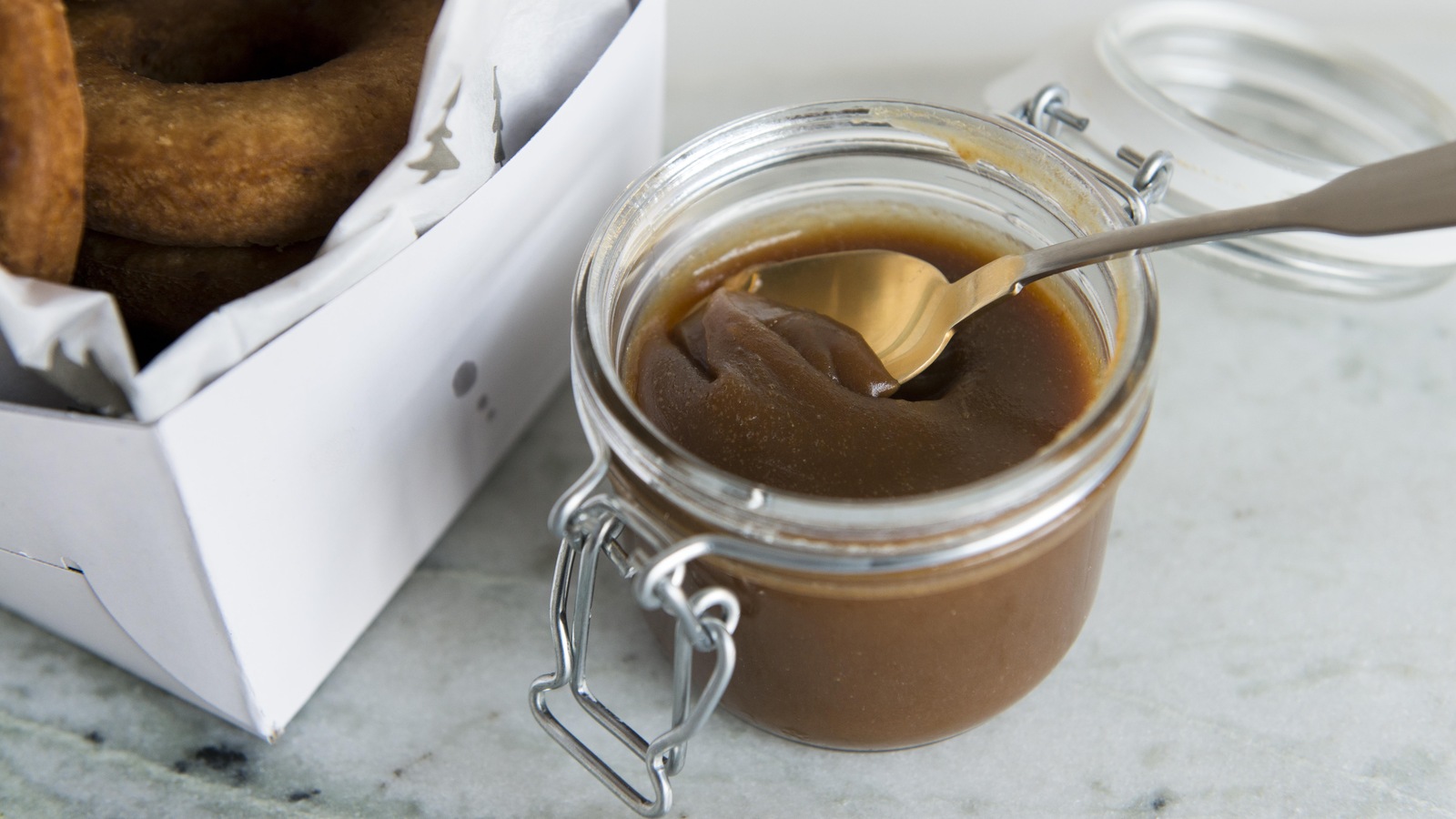 Une cuillère est plantée dans un pot de caramel. Une cuillère est plantée dans un pot de caramel.