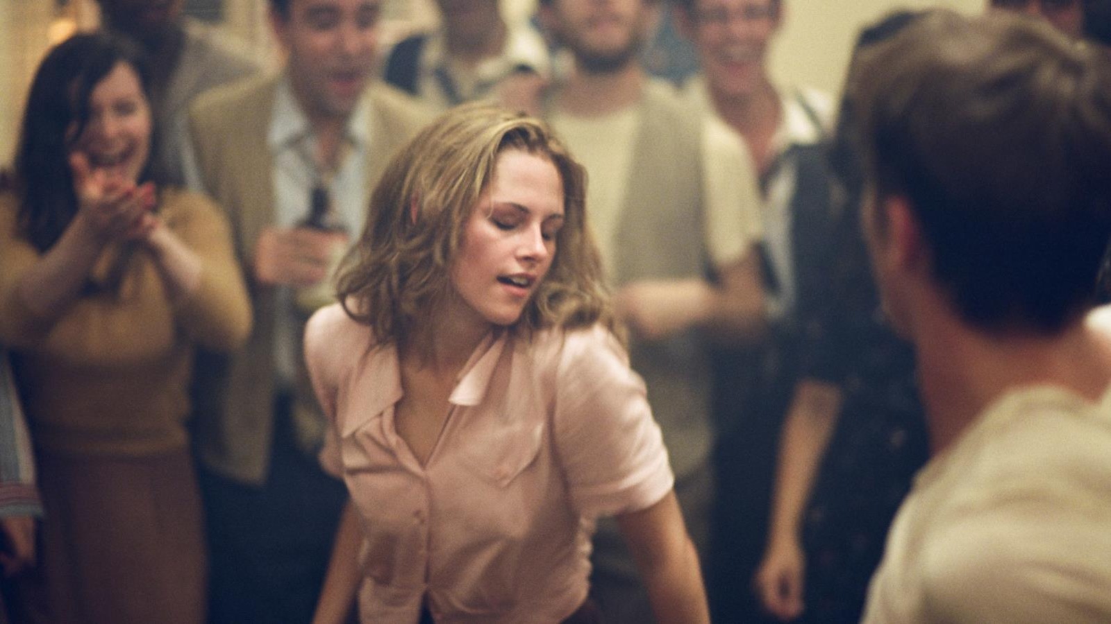 Une jeune fille en chemisier rose danse au milieu d'une foule Une jeune fille en chemisier rose danse au milieu d'une foule