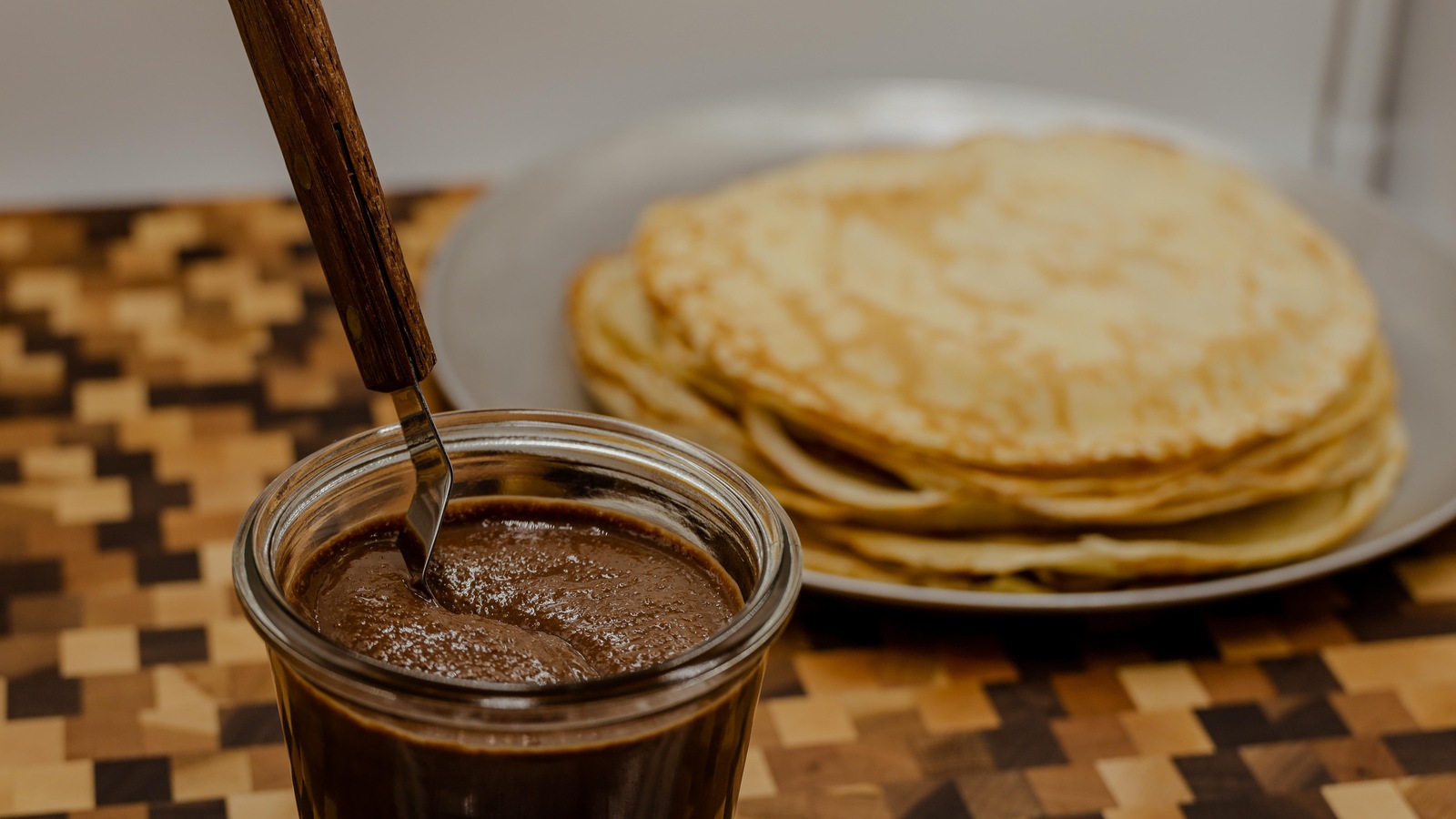 Pot de chocolat en avant plan et assiette de crêtes derrière. Pot de chocolat en avant plan et assiette de crêtes derrière.
