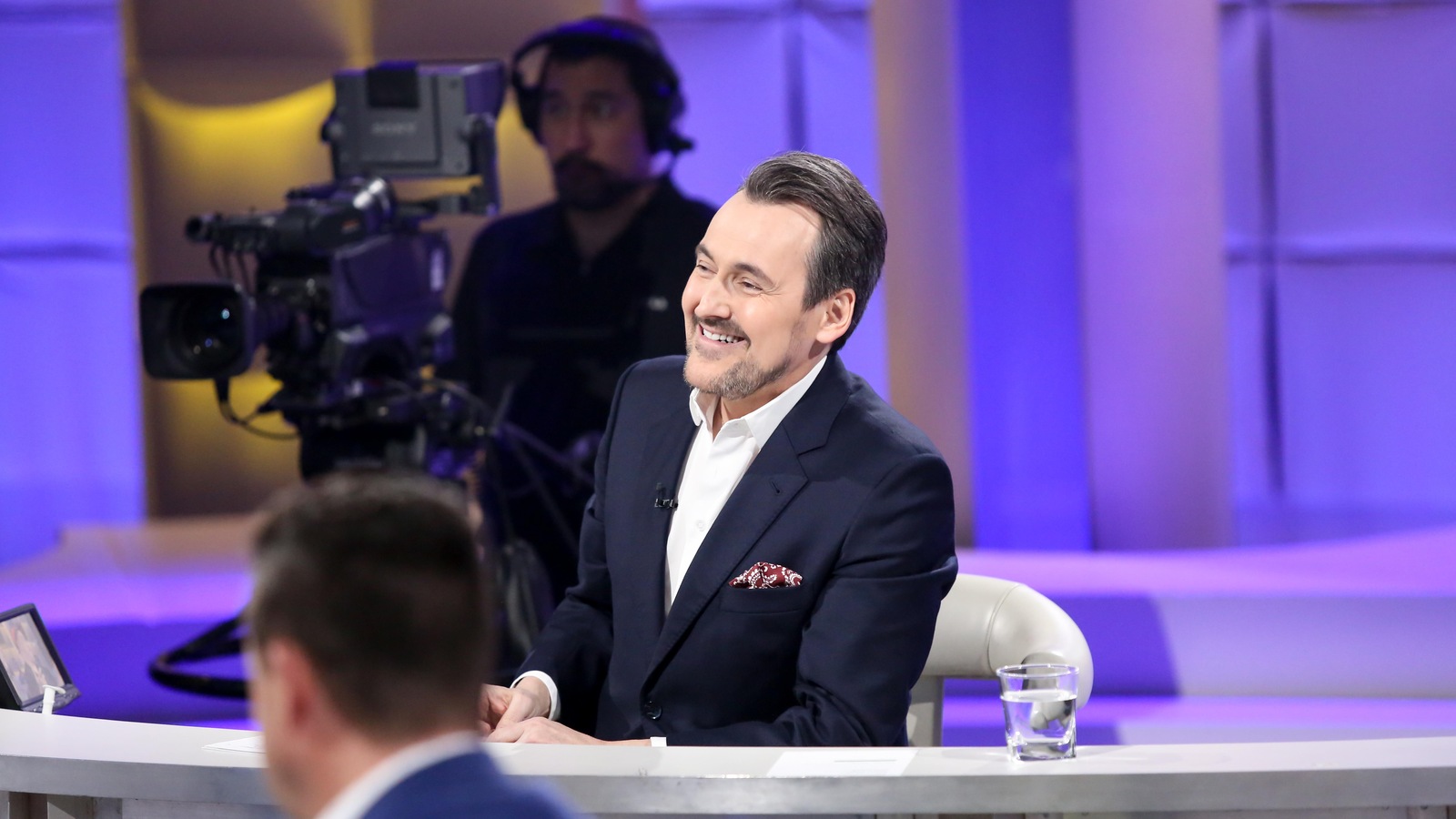 L'animateur Guy A Lepage est assis sur son siège d'intervieweur et regarde ses invités. L'animateur Guy A Lepage est assis sur son siège d'intervieweur et regarde ses invités.