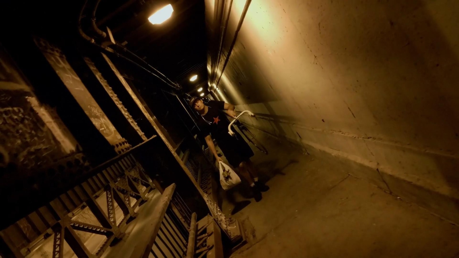 Un homme (Guillaume Laurin) porte son vélo, dans un couloir. Un homme (Guillaume Laurin) porte son vélo, dans un couloir.