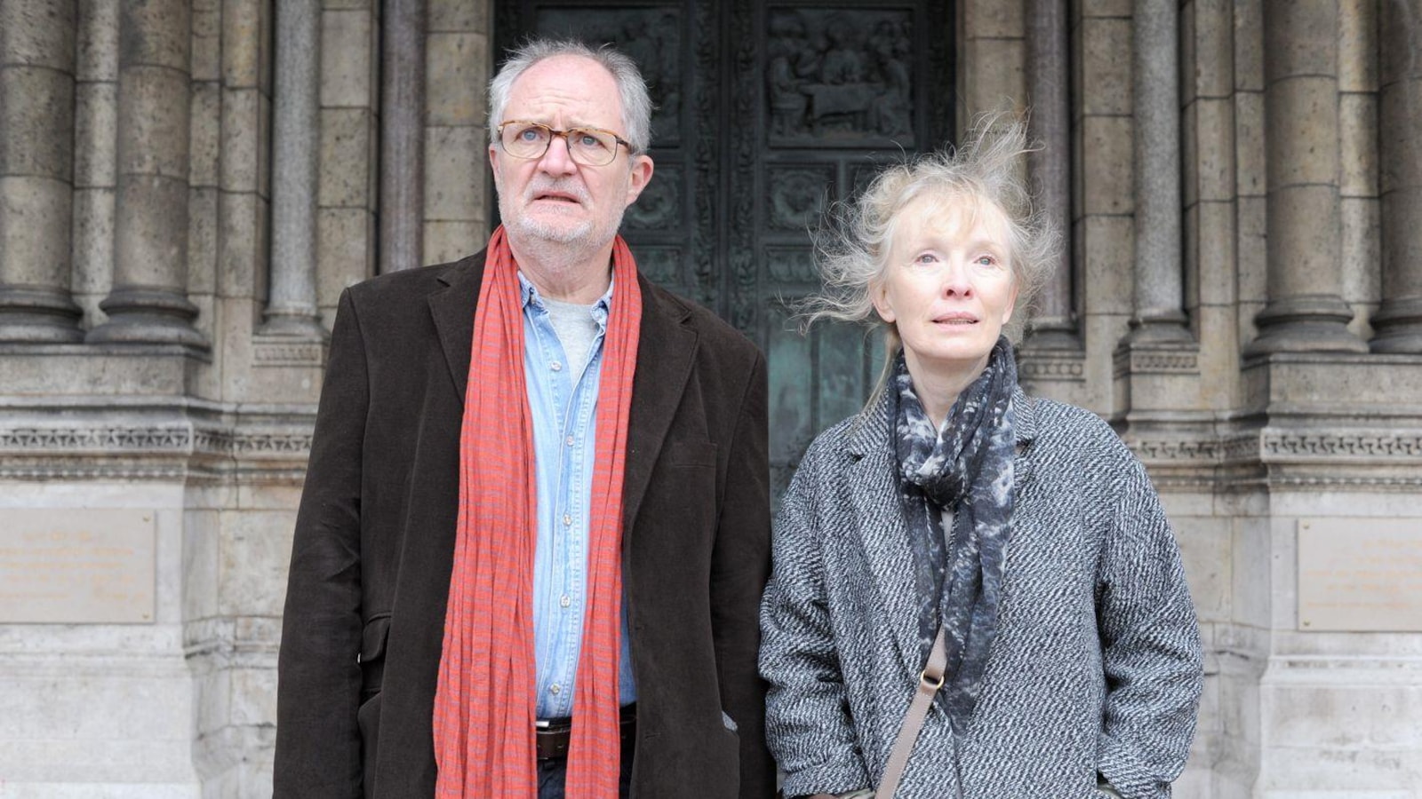 Un homme et une femme devant la porte d'une église en pierres. Un homme et une femme devant la porte d'une église en pierres.