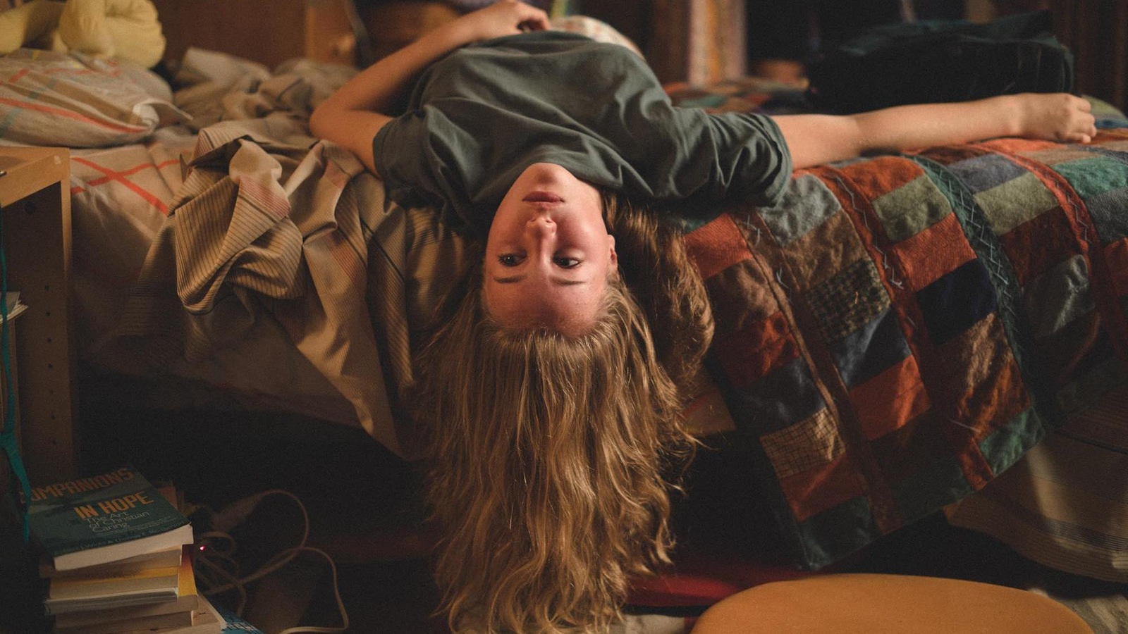 Une jeune fille (Émilie Bierre) couchée sur le dos sur un lit, la tête pendant à l'envers. Une jeune fille (Émilie Bierre) couchée sur le dos sur un lit, la tête pendant à l'envers.