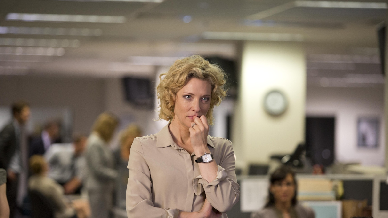 Une femme blonde, dans une salle de rédaction, l'air soucieuse. Une femme blonde, dans une salle de rédaction, l'air soucieuse.